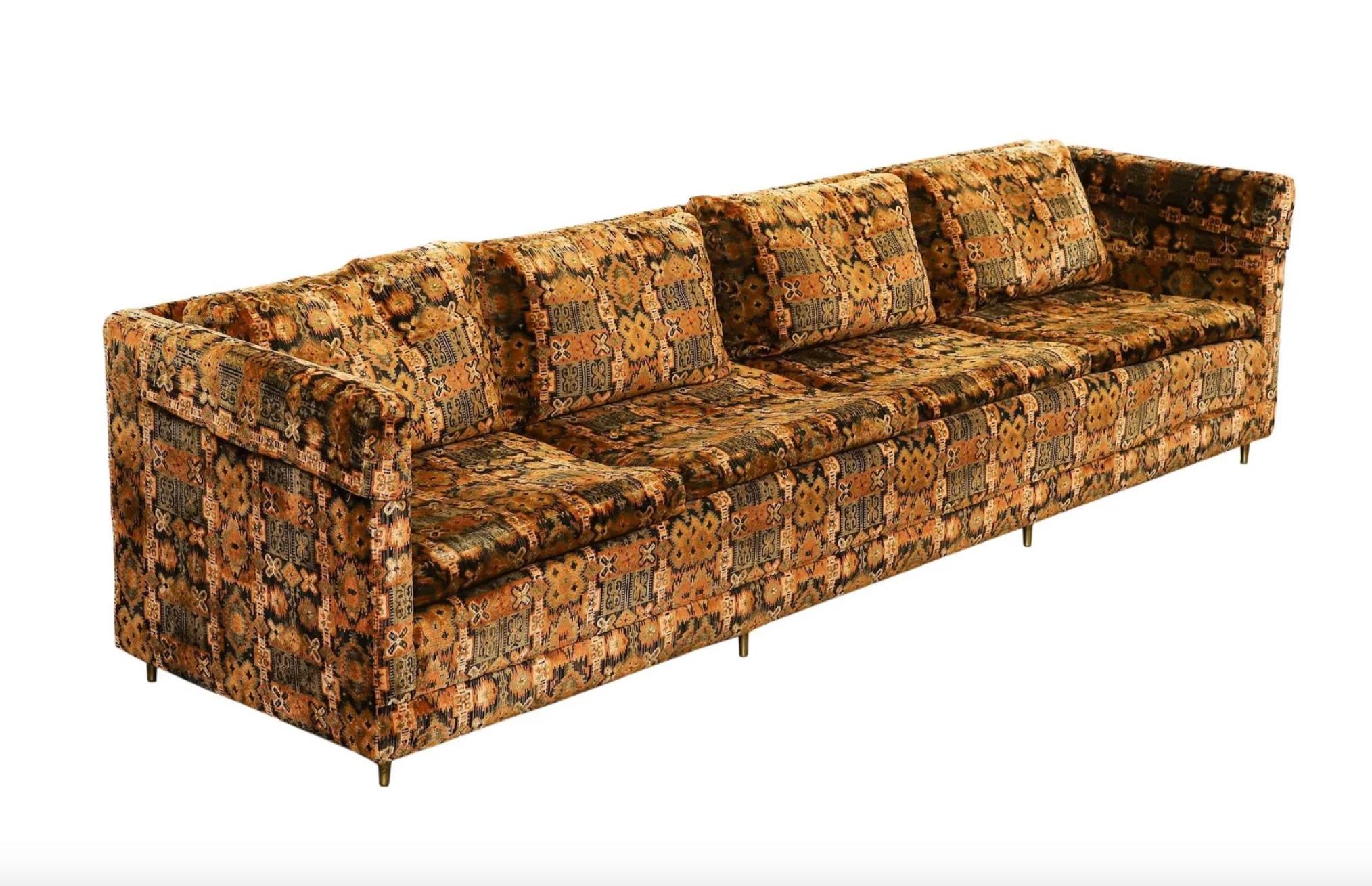A stunning oversized tuxedo sofa featuring original Jack Lenor Larsen polychrome velvet upholstery with a bold repeating geometric motif. Designed in the Paul McCobb style, this mid-century modern statement piece boasts clean lines, brass cigar