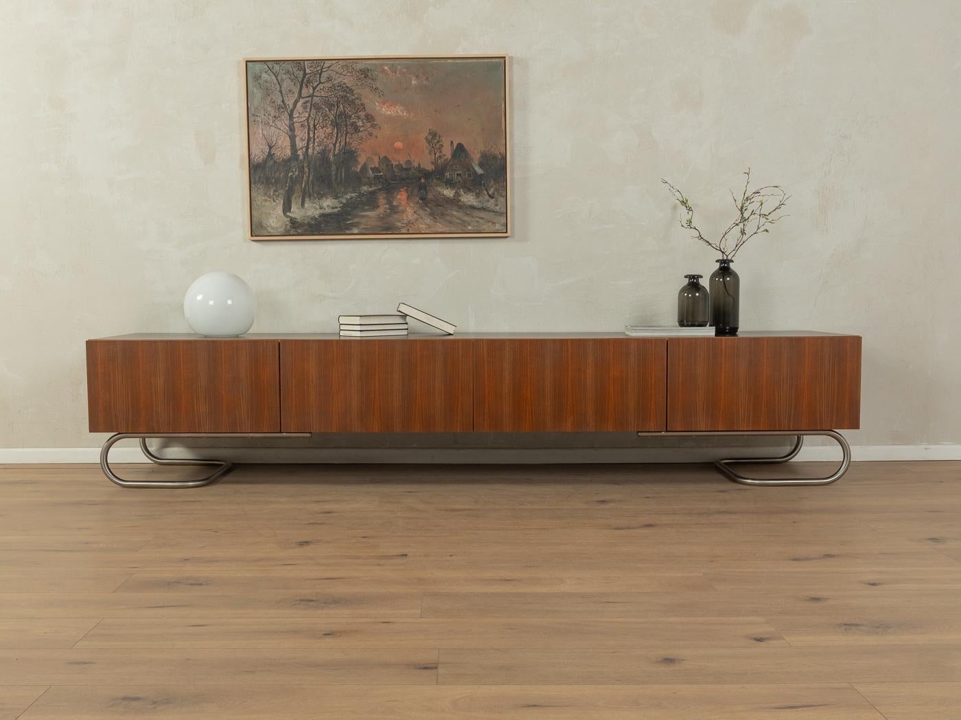 Unique sideboard from the 1960s. Corpus in walnut veneer with four drawers and new stainless steel feet in Bauhaus design. The top is coated with black Formica.

Quality Features:
very good workmanship
high-quality materials
solid wood drawer
Made