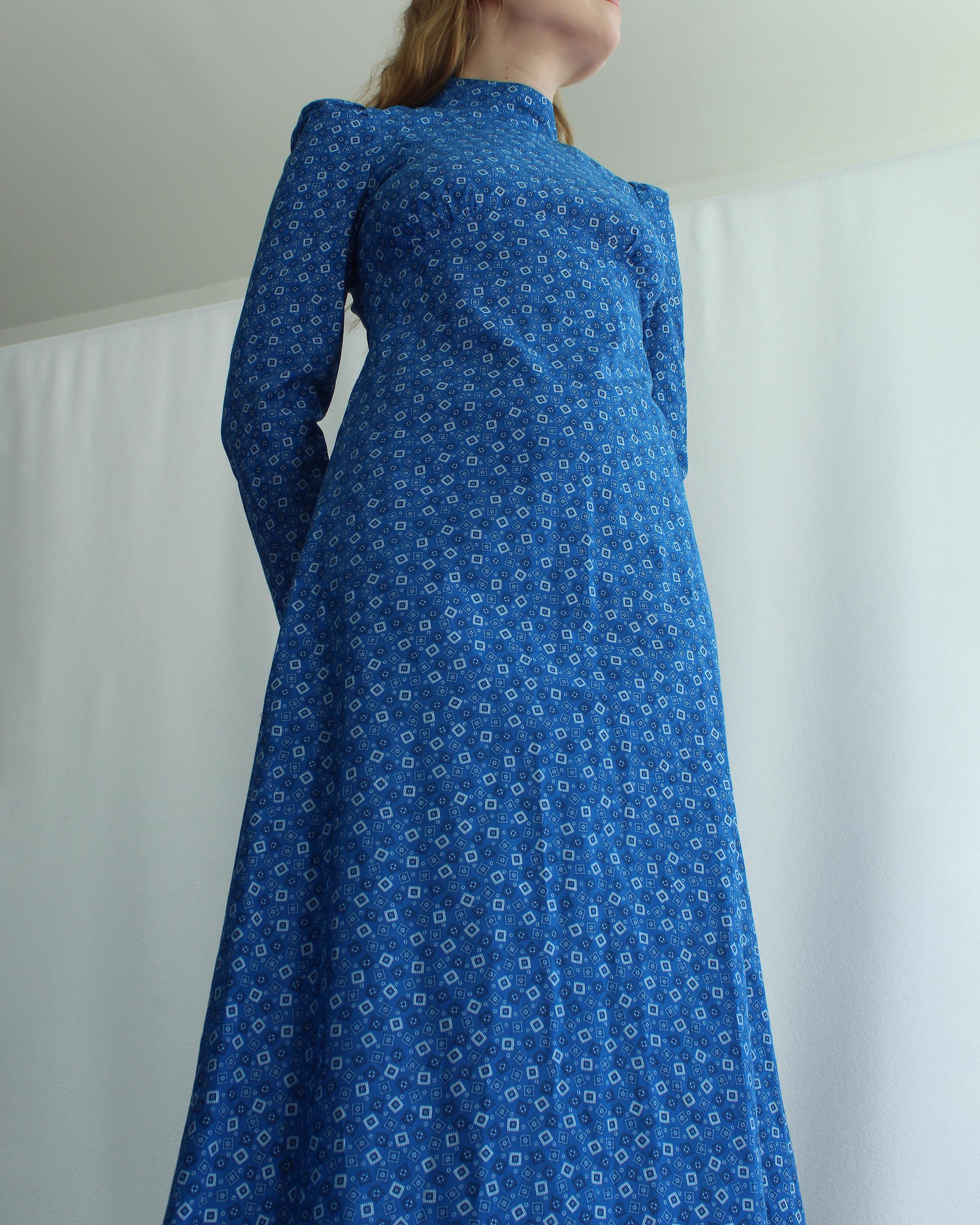 VERY BREEZY presents: This deadstock vintage 1960s cobalt calico dress draws inspiration from Victorian wrapper dresses, creating a romantic bohemian look. It features a mock neck and empire waist— would be great for an early maternity dress! The