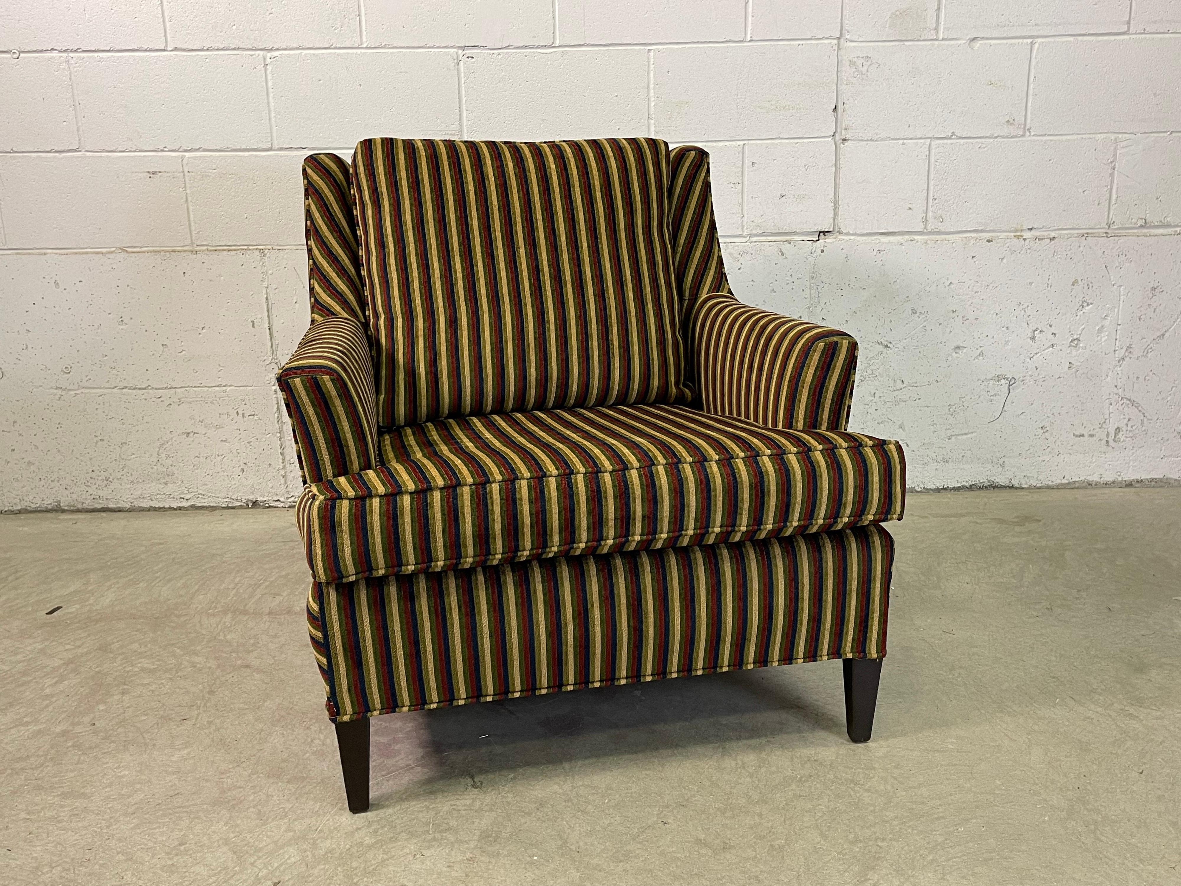Vintage 1960s armed lounge chair with new striped fabric upholstery. The chair is sturdy and comfortable with new foam seating. Arms and back have a slight curve design. The feet are a square wood style. Seat 17.5” H. No marks.