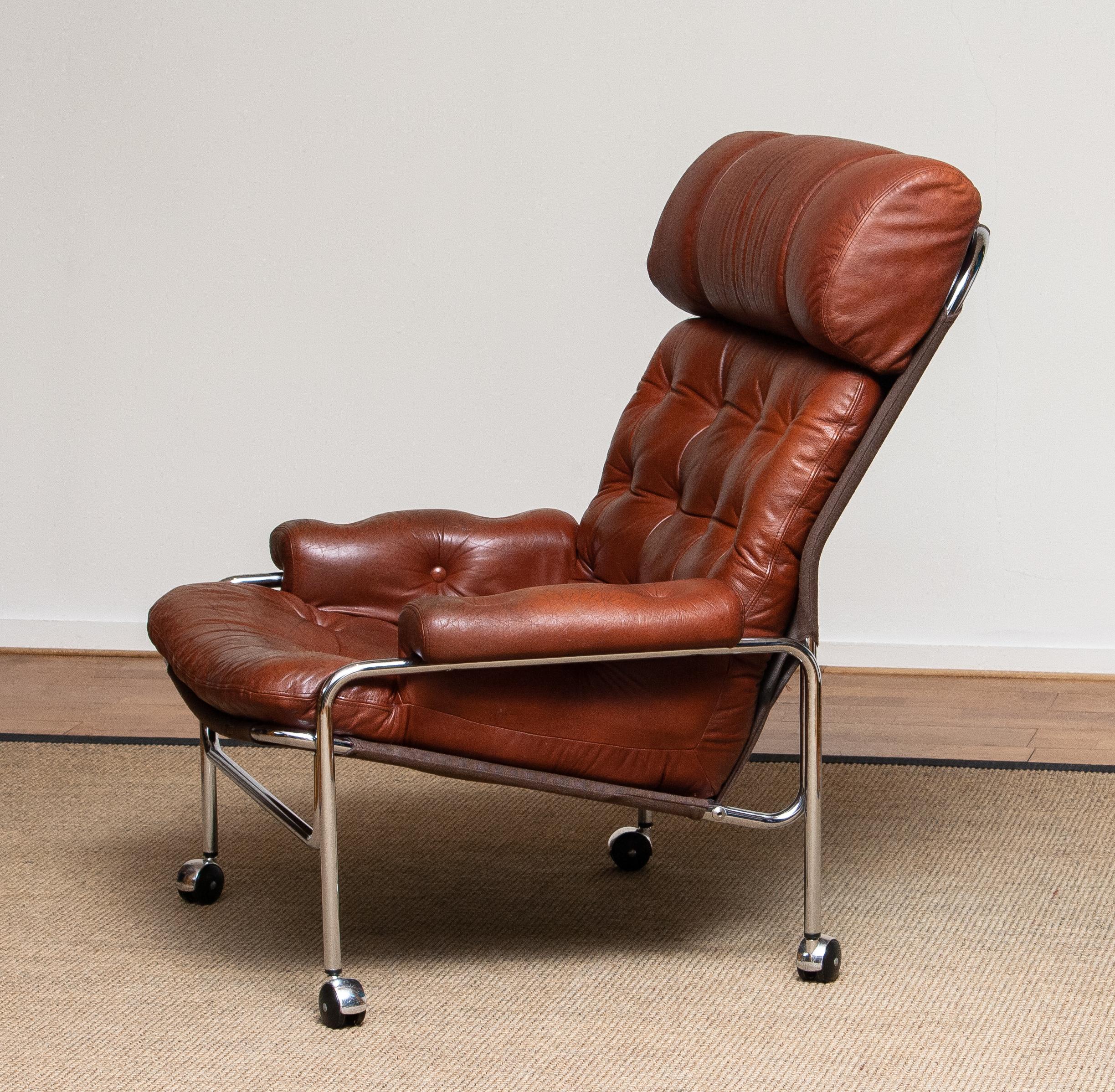 Beautiful lounge / easy chair in aged brown / cognac leather and chrome designed by Pethrus Lindlöfs for A.B. Lindlöfs Möbler Lammhult, Sweden.
The aged leather on the chairs gives the chairs the typical vintage character. The leather is soft and