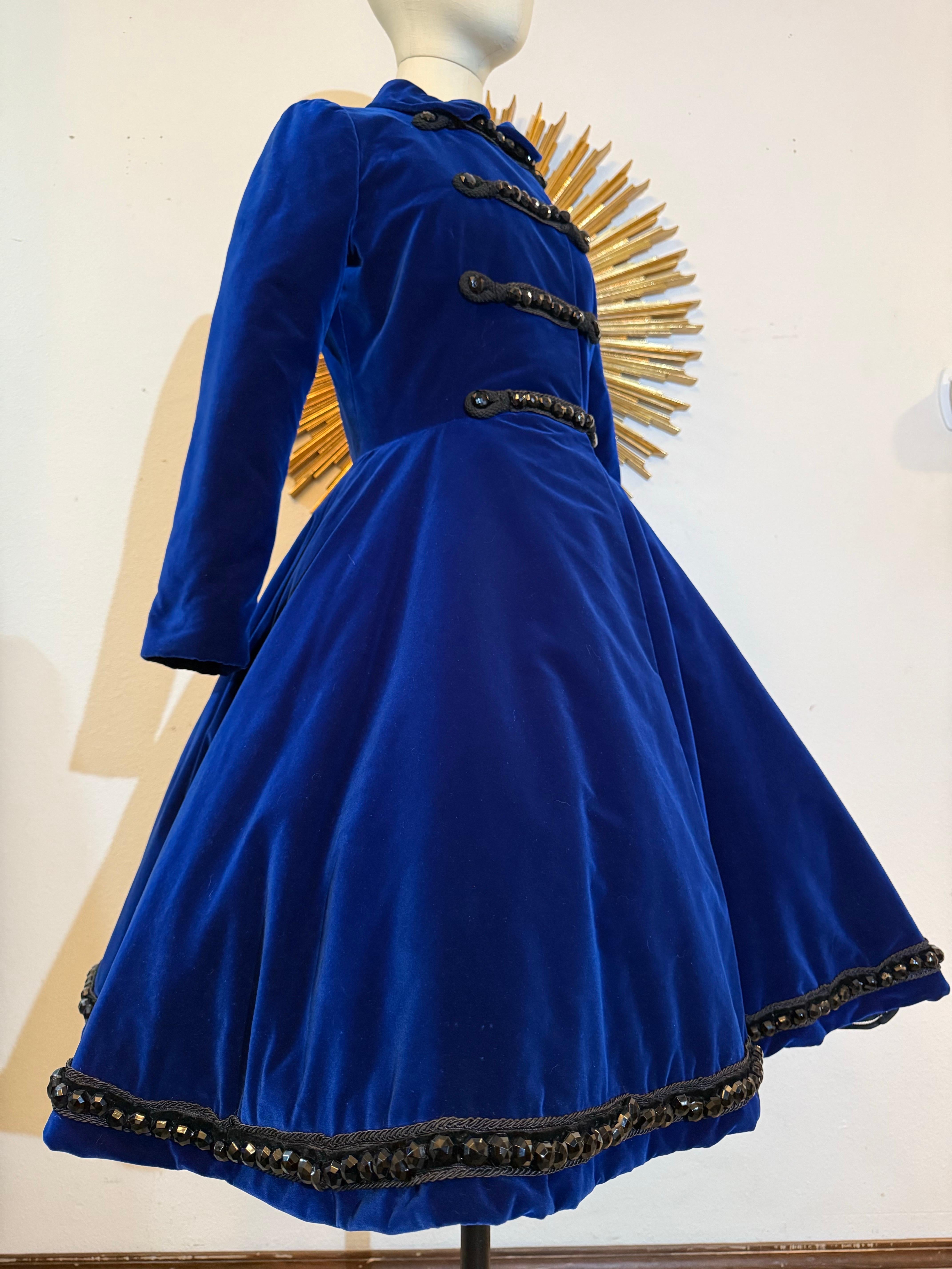 Lucie-Spilo 1960, velluto di seta blu zaffiro, cappotto di ispirazione militare con perline di getto antiche:  Cappotto in stile napoleonico in lussuoso velluto di seta, con corpetto aderente e gonna ampia e svasata (nelle foto è mostrato con una