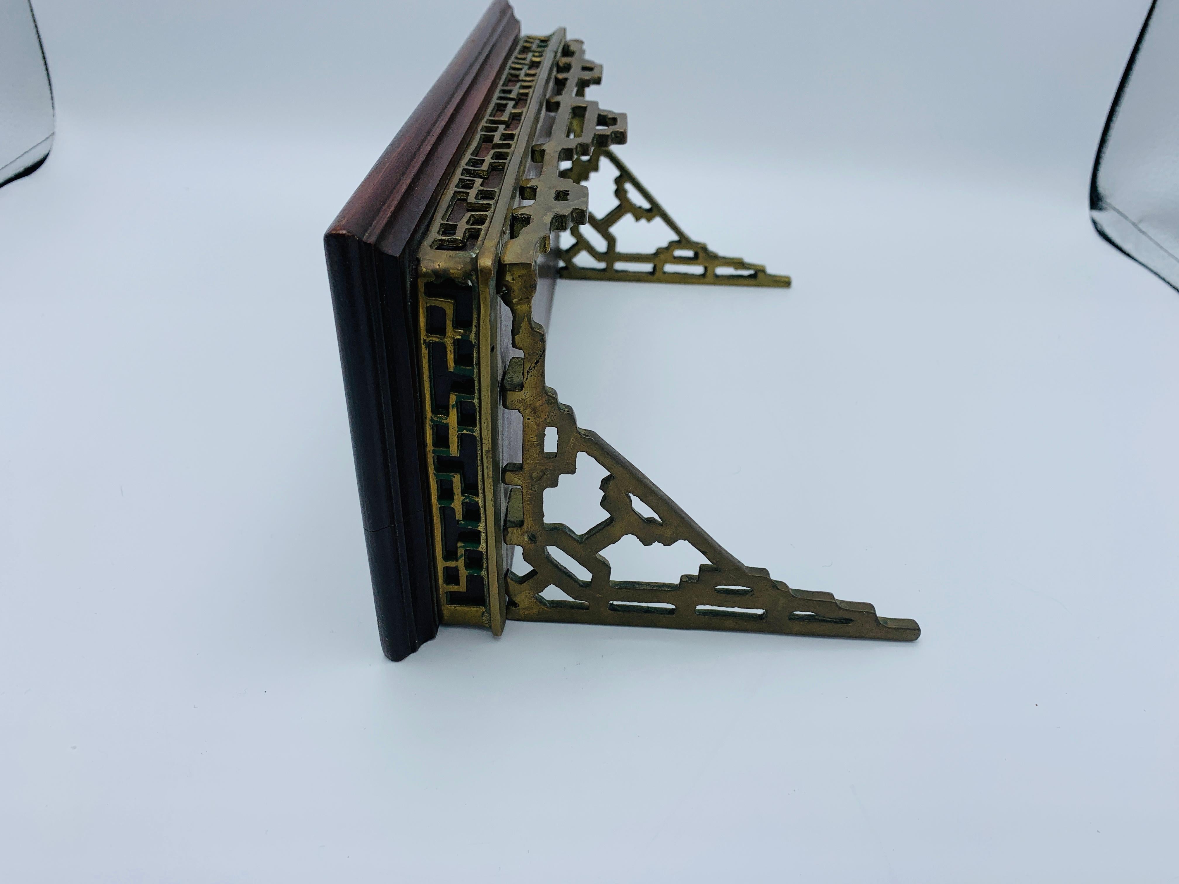 Listed is a stunning, single 1960s chinoiserie mahogany and brass wall shelf bracket. The piece has a beautiful, mahogany wood shelf with a Chinoiserie Greek key motif in the brass bracket beneath. Heavy, weighing 3.5lbs.