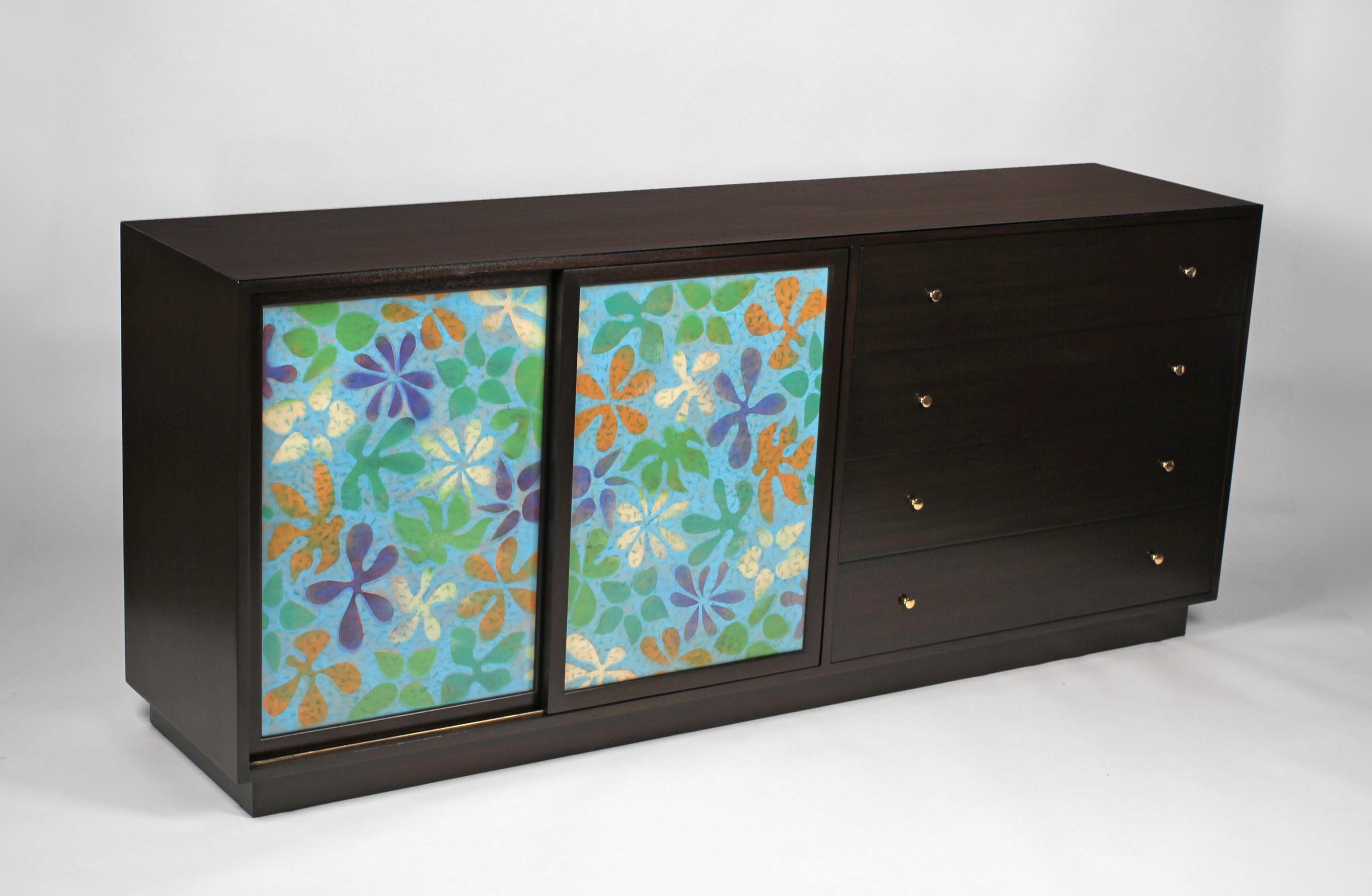 Cabinet or dresser designed by Harvey Probber. Cabinet has high-fired enamel-on-copper doors with a floral decorative motif and are in excellent condition. The dark mahogany case has four exterior drawers with brass pulls. The sliding enameled doors