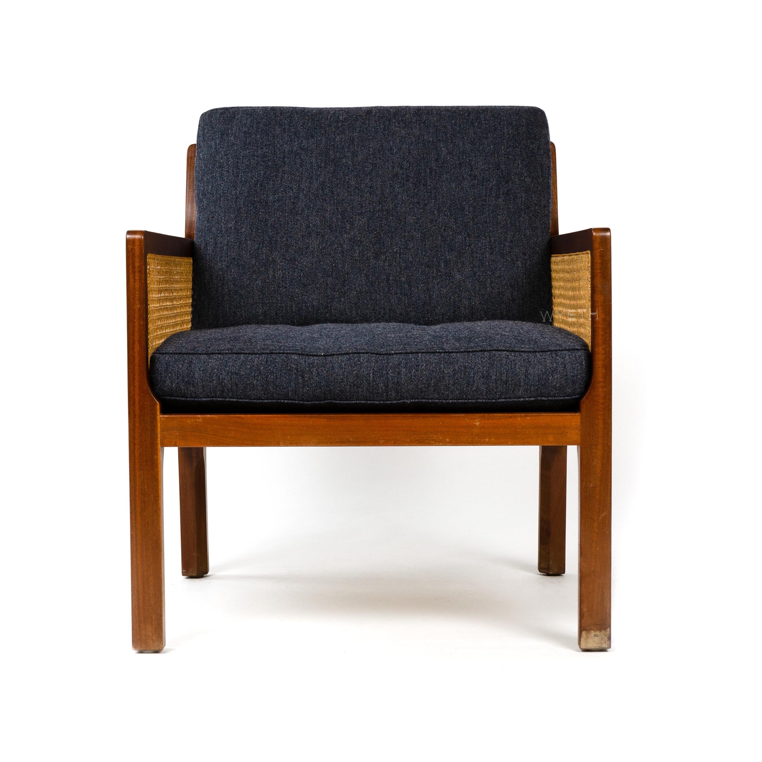 A mahogany lounge chair with traditional hand-caned back and side panels, with newly upholstered dark grey Savak wool seat and back cushions.