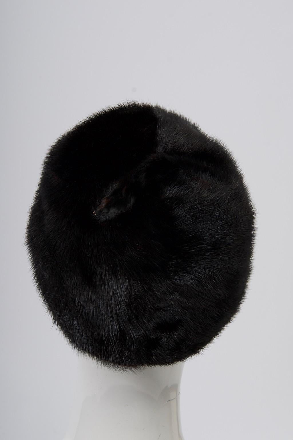 Dark mahogany mink skins distinguish this hat, finished on top with the subtle touch of a small claw. Lined with brocade, looks hardly worn. Retailed by Ohrbach's boutique Oval Room. Interior measurement 21.5
