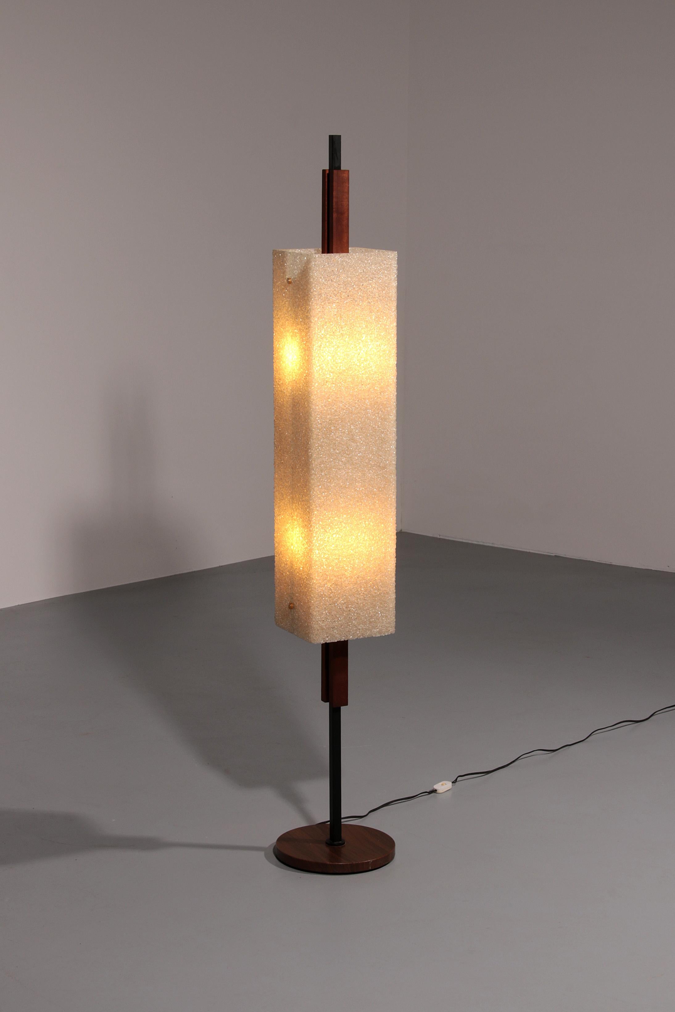 his elegant Mid-Century floor lamp was designed by Maison Arlus and crafted in France during the 1960s. A refined blend of materials defines its structure: a wooden base with teak elements anchored on a sturdy metal frame. The distinctive hood is