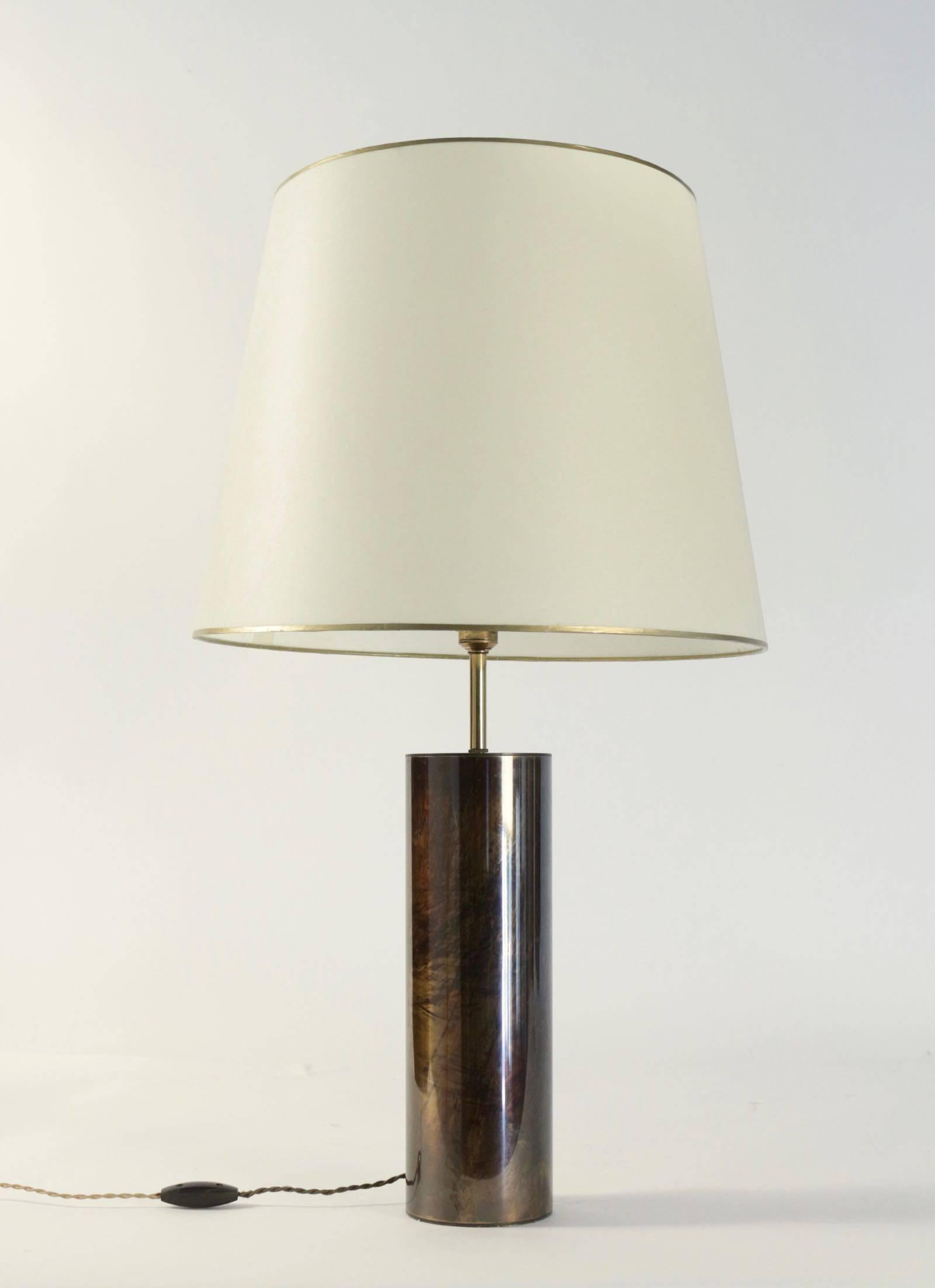 1970s, Maison Honoré table lamp.

Composed of a base formed by a brass cylinder with a brown and golden patina.
It is dressed with a lampshade of parchment style, enhanced with 2 golden bands at the top and bottom. (original lampshade)
At the top of