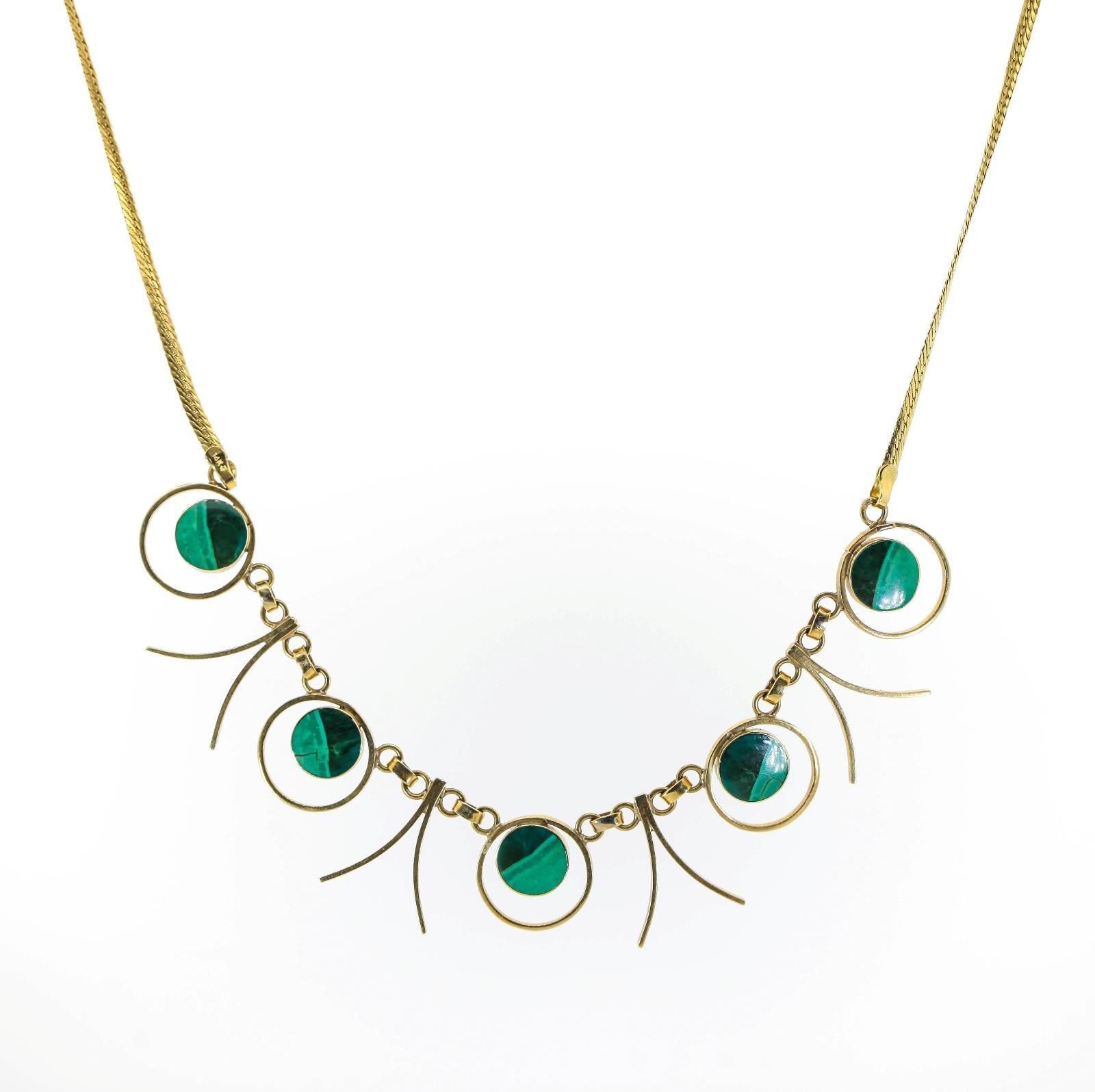 Stylish and dashing this 1960s necklace composed of five flat bezel set round Malachite plaques.  Four alternating gold whiskers add to the movement of this lively piece.  A 14KT yellow gold flat link chain completes it.  Very fashionable!  