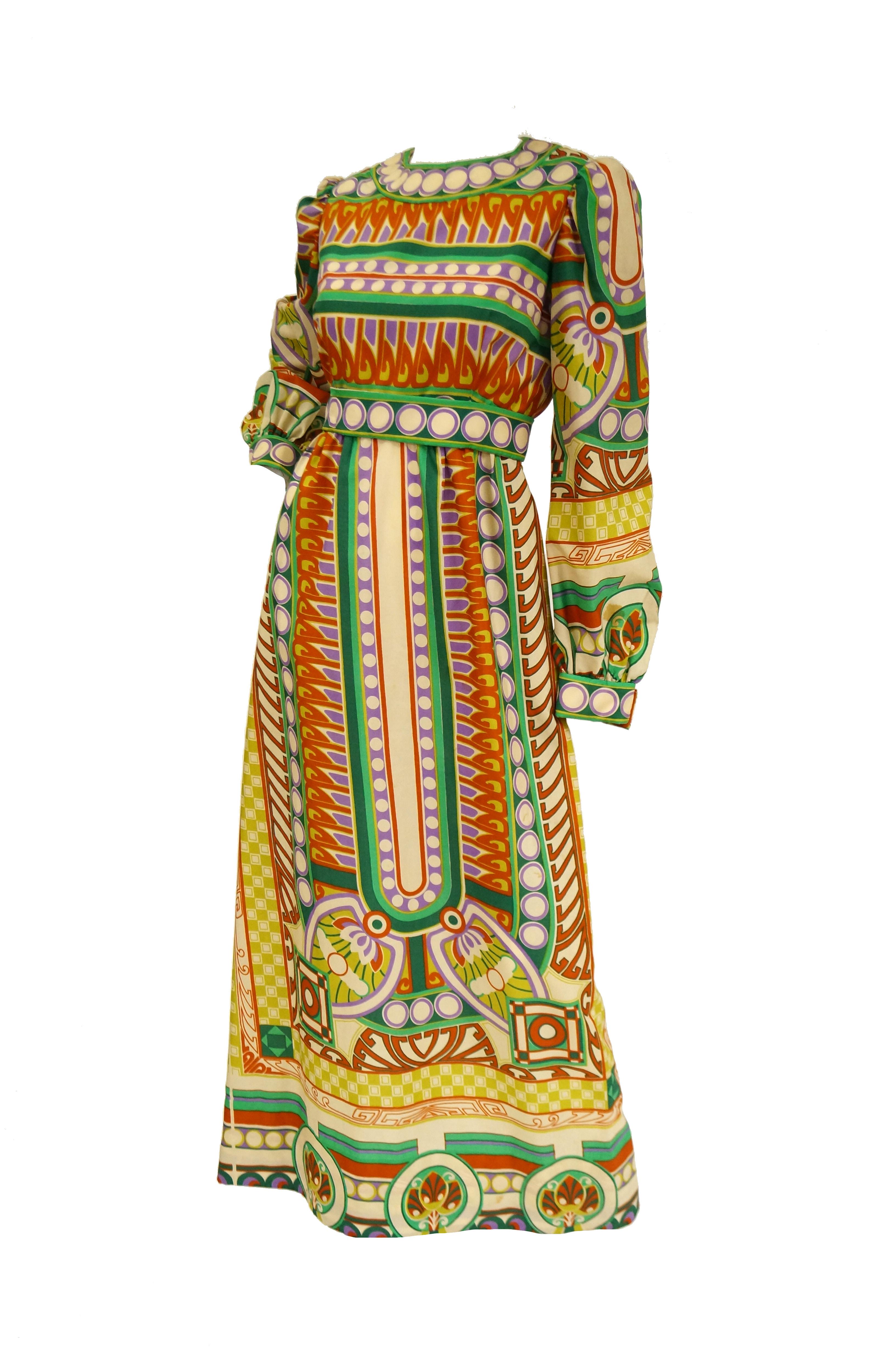 Beautiful intricately printed dress by Youssef Rizkallah for Malcolm Starr. The dress is maxi length, with an A - Line silhouette, long bishop sleeves with a wide cuff, a fitted bodice, and a wide jewel neckline. The dress is brilliant and colorful,