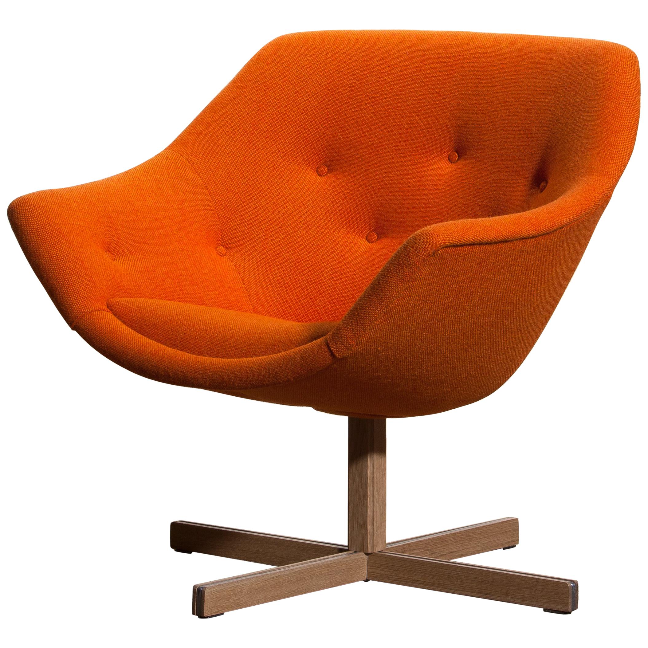 Fantastic 'Mandarini' swivel armchair made by Carl Gustaf Hiort for Puunveisto Oy, wood work Ltd. This chair is upholstered with a buttoned orange fabric 'Hallingdal' by Kvadrat designed by Nanna Ditzel, on an oak swivel base.
It is in perfect and