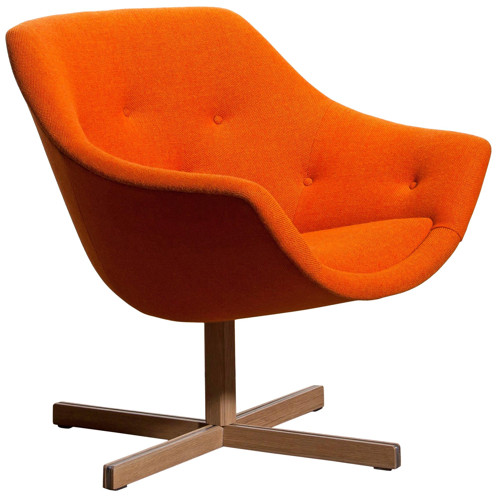 Fantastic 'Mandarini' swivel armchair made by Carl Gustaf Hiort for Puunveisto Oy, wood work Ltd. This chair is upholstered with a buttoned orange fabric 'Hallingdal' by Kvadrat designed by Nanna Ditzel on an oak swivel base.
It is in perfect and