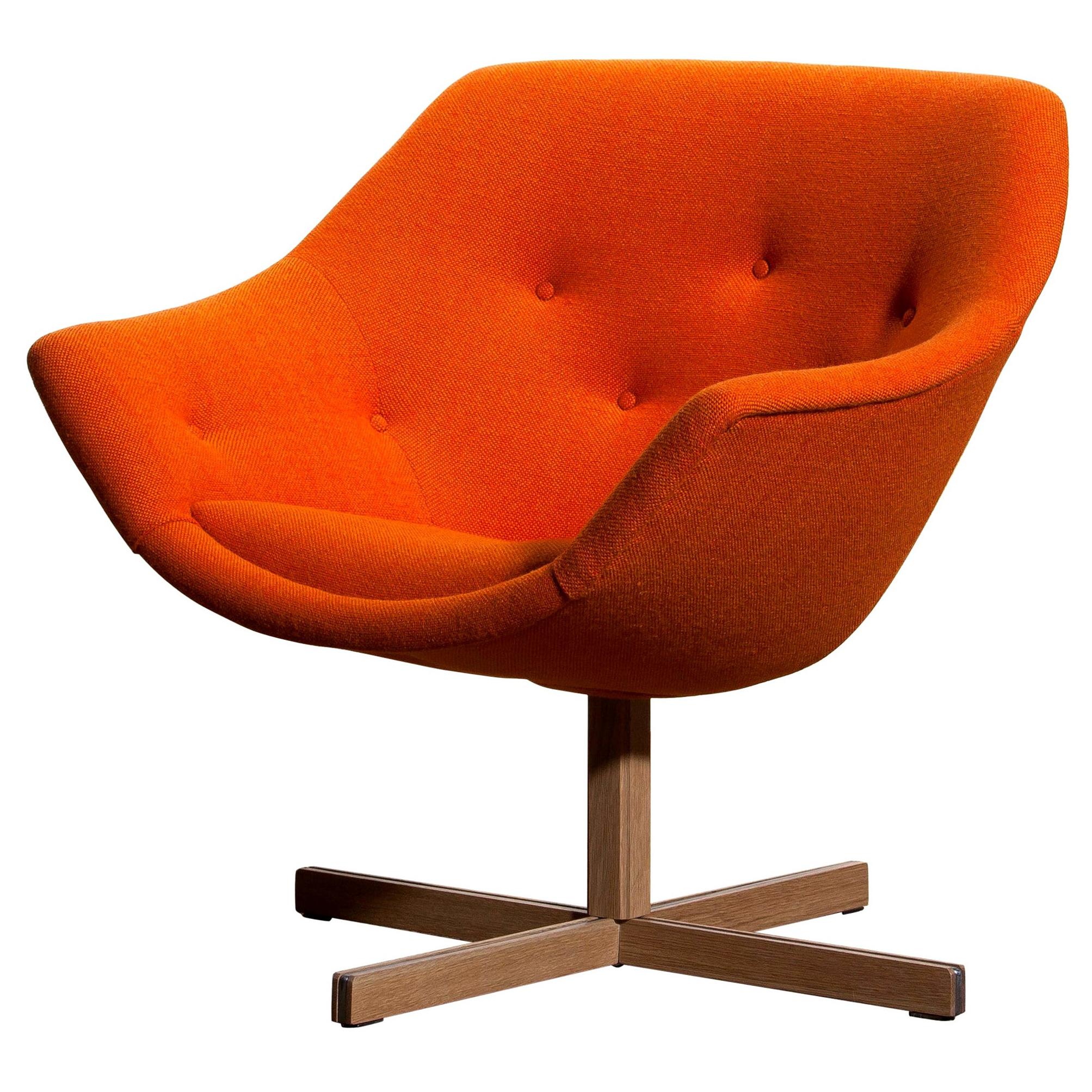 Fantastic 'Mandarini' swivel armchair made by Carl Gustaf Hiort for Puunveisto Oy, wood work Ltd. This chair is upholstered with a buttoned orange fabric 'Hallingdal' by Kvadrat designed by Nanna Ditzel, on an oak swivel base.
It is in perfect and