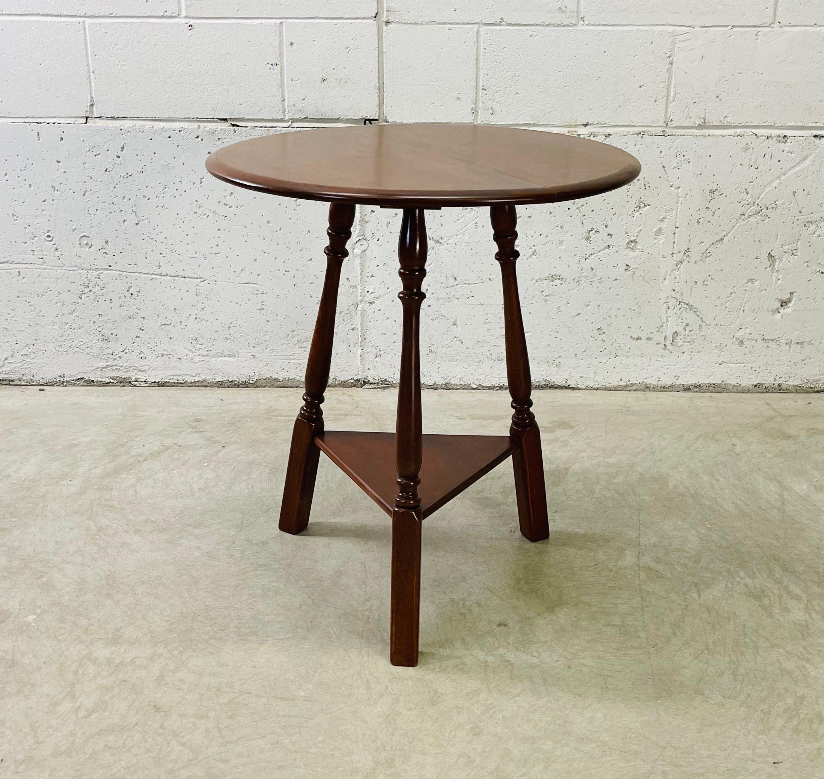 Vintage 1960s maple wood round top side table with a bottom shelf. The table has three legs and the bottom shelf is 8”H. Newly refinished condition. The table is sturdy. No marks.