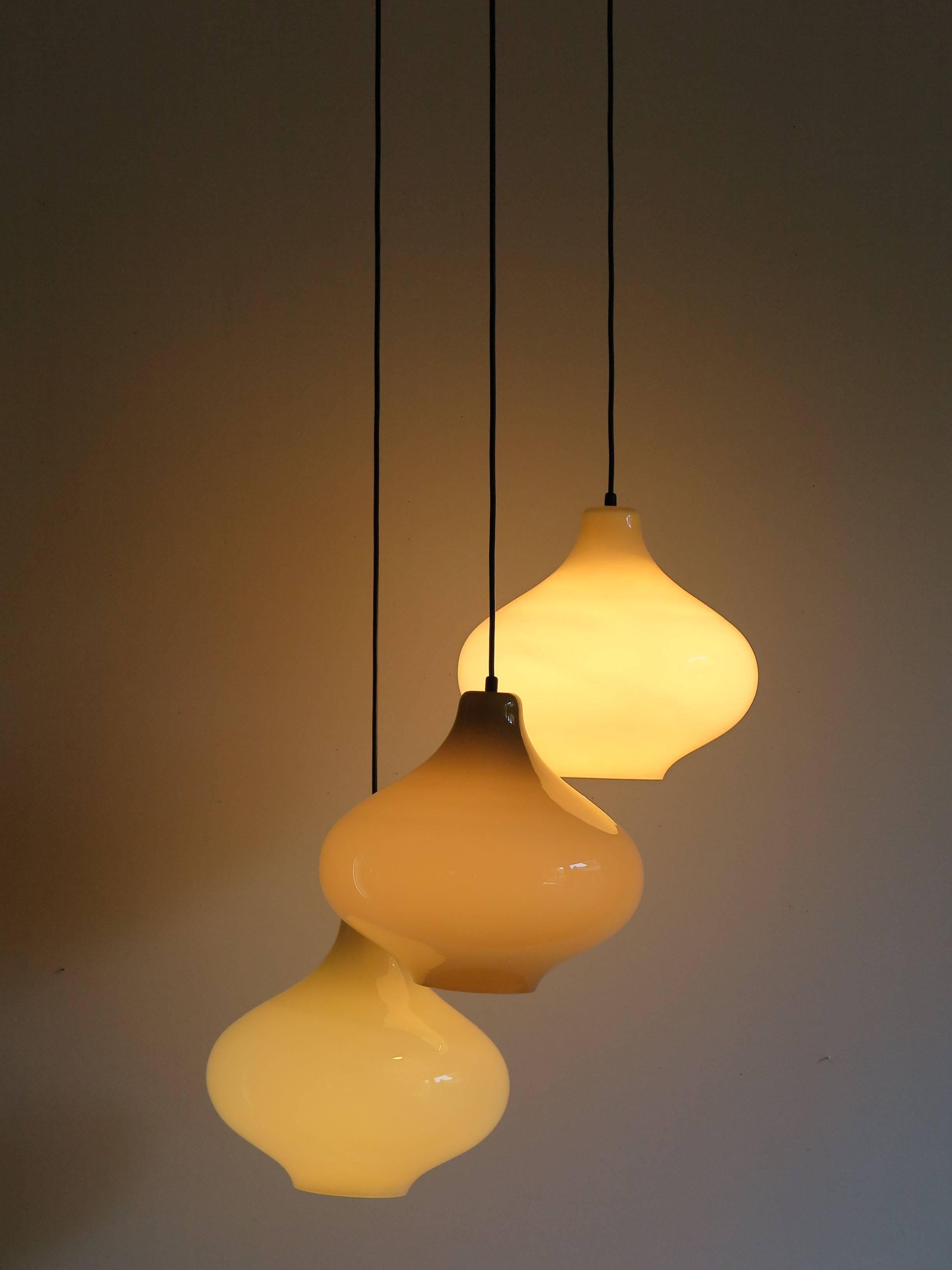 1960s pendant lamp composed by three lights “onion-shape” diffusers made by opalescent glass, dove-gray color, designed by Massimo Vignelli, corresponding to the Venini’s design n°4039.
Cylindrical brass ceiling elements designed by Lino