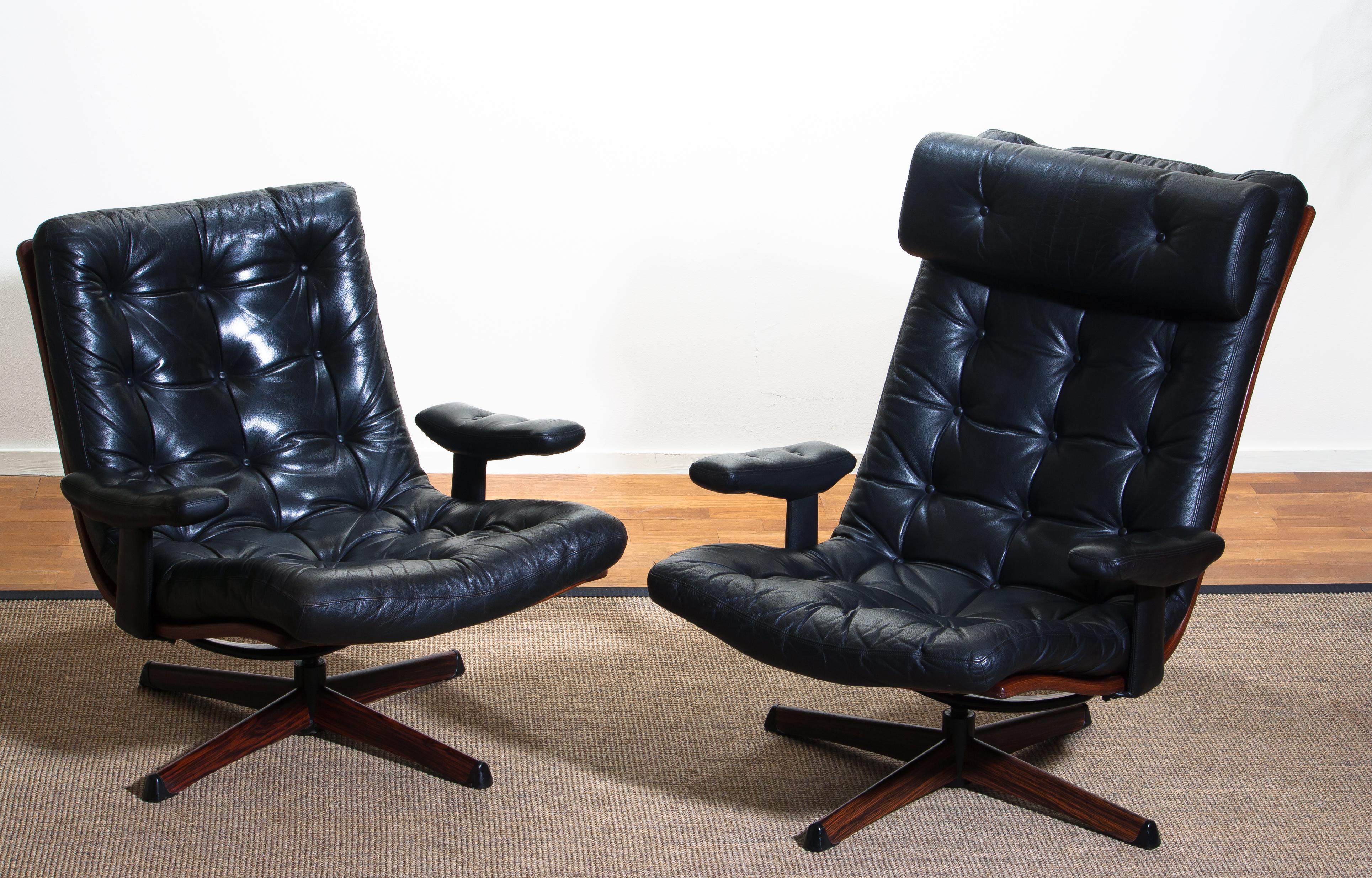 Beautiful set of two extremely comfortable and matching swivel chairs by Gote Design Nassjo Sweden, 1960
The metal swivel stands are covered with an Jakaranda print.
The chairs are upholstered with black sturdy leather and all in perfect