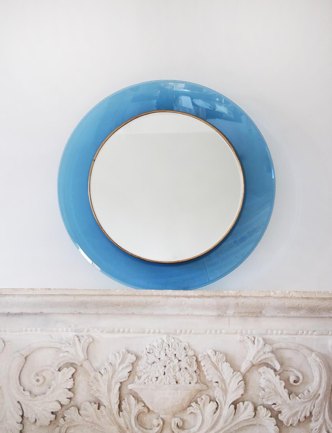 A stunning and rare example of a deep blue circular glass mirror designed by Max Ingrand and made by Fontana Arte in 1966. The mirror is surrounded by a concave glass frame in deep blue. The model number for this historic design piece is 1669 and it