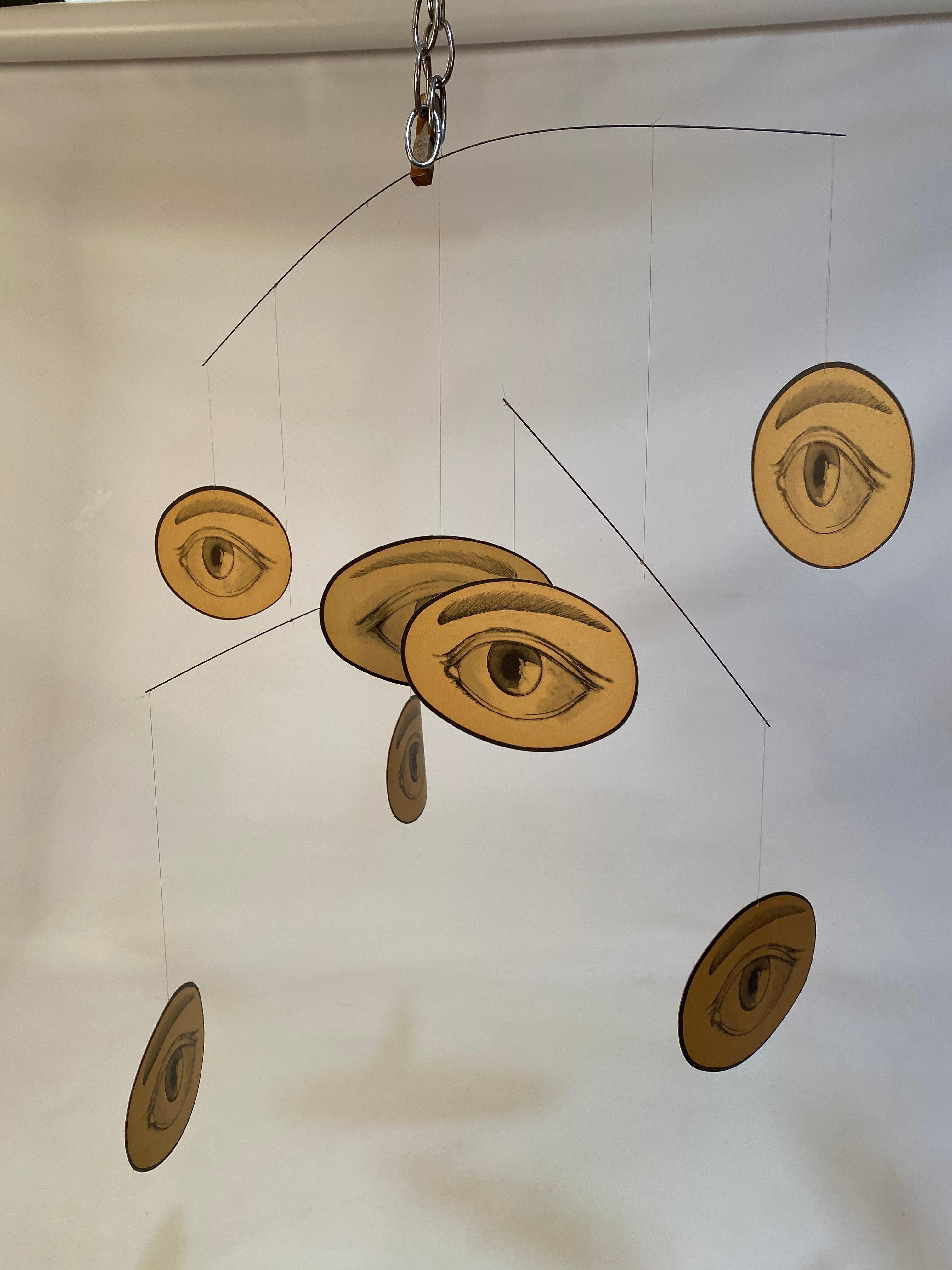 Eye mobile in the style of M.C. Escher's 1946 rendition of the eye. Seven heavy stock printed paper eyes on three metal rods attached with invisible filament, circa 1960-1970. Good condition some darkening of paper due to age. Some minor