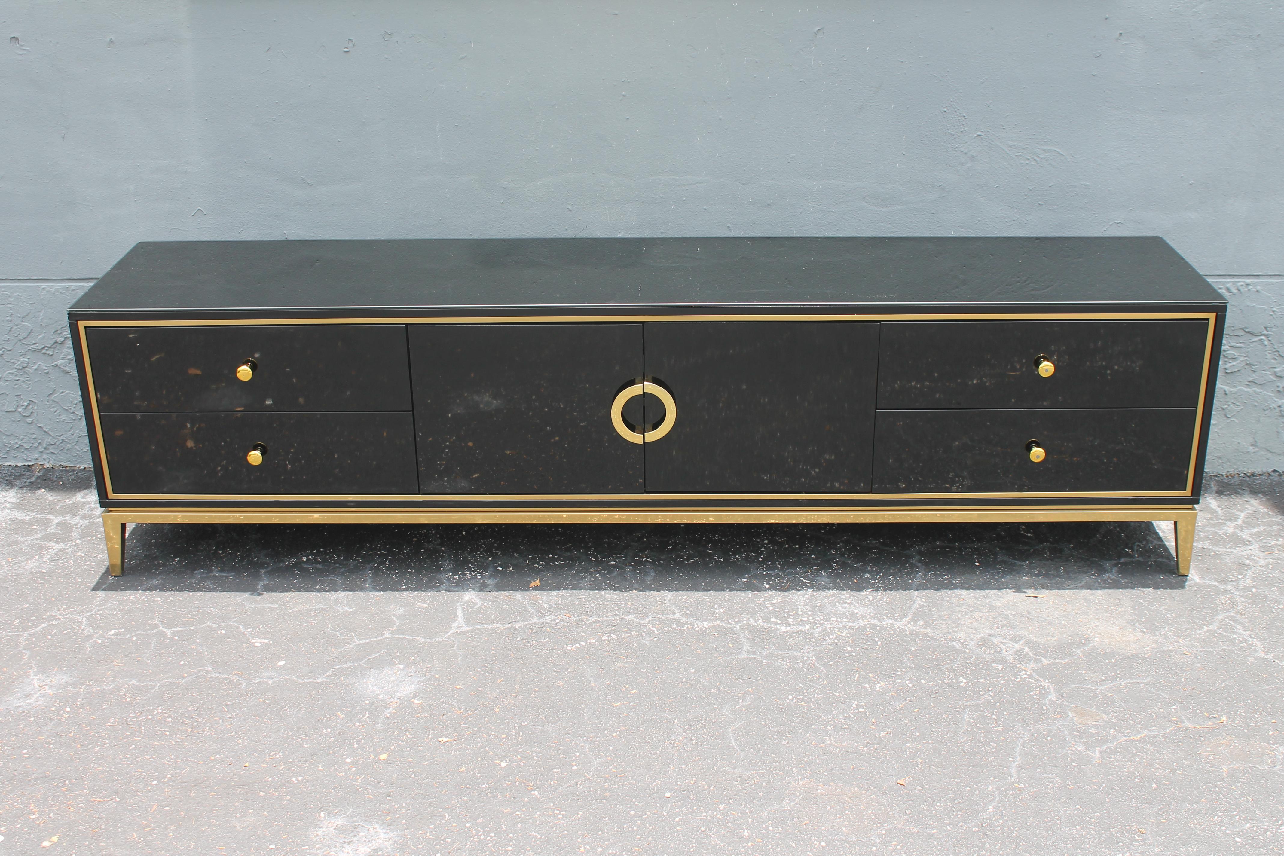 1960's Mid Century Modern Black Lacquer Low Buffet/ Sideboard/ Credenza in the style of Pierre Cardin. This piece would work well under the television or behind the sofa. Beautiful brass accents. Lots of storage space.