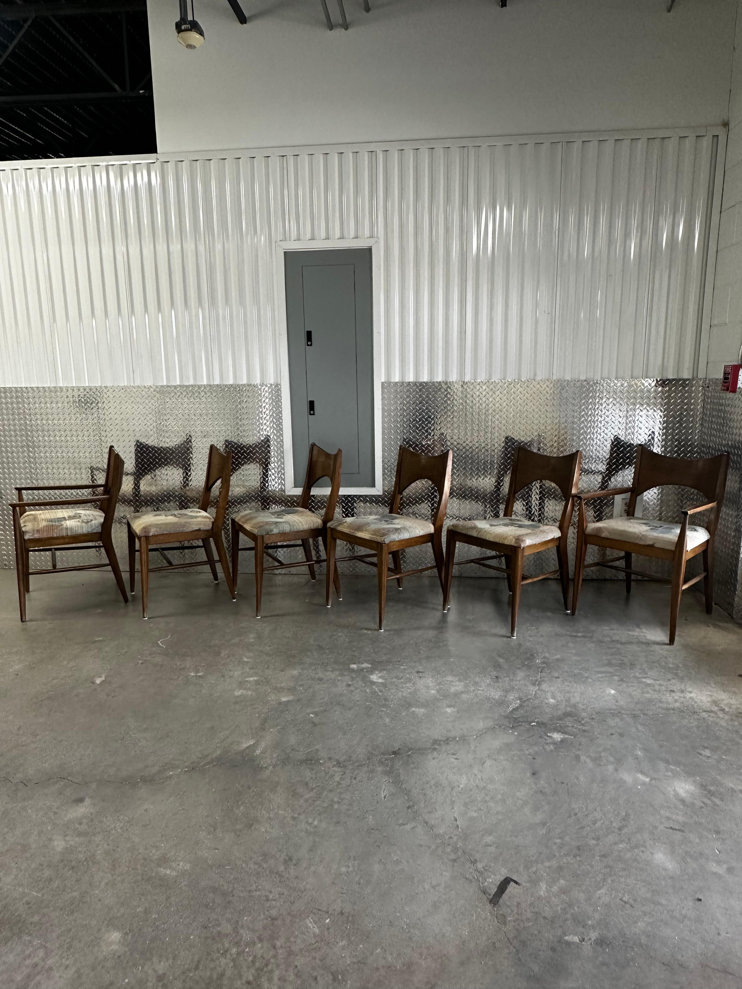 Set of six stunning Mid-Century Modern walnut dining chairs from Broyhill Premier’s “Saga” collection, in the style of Paul McCobb. The solid walnut frames feature modern styling with a distinct beautiful design. Sculpturally carved bow-tie