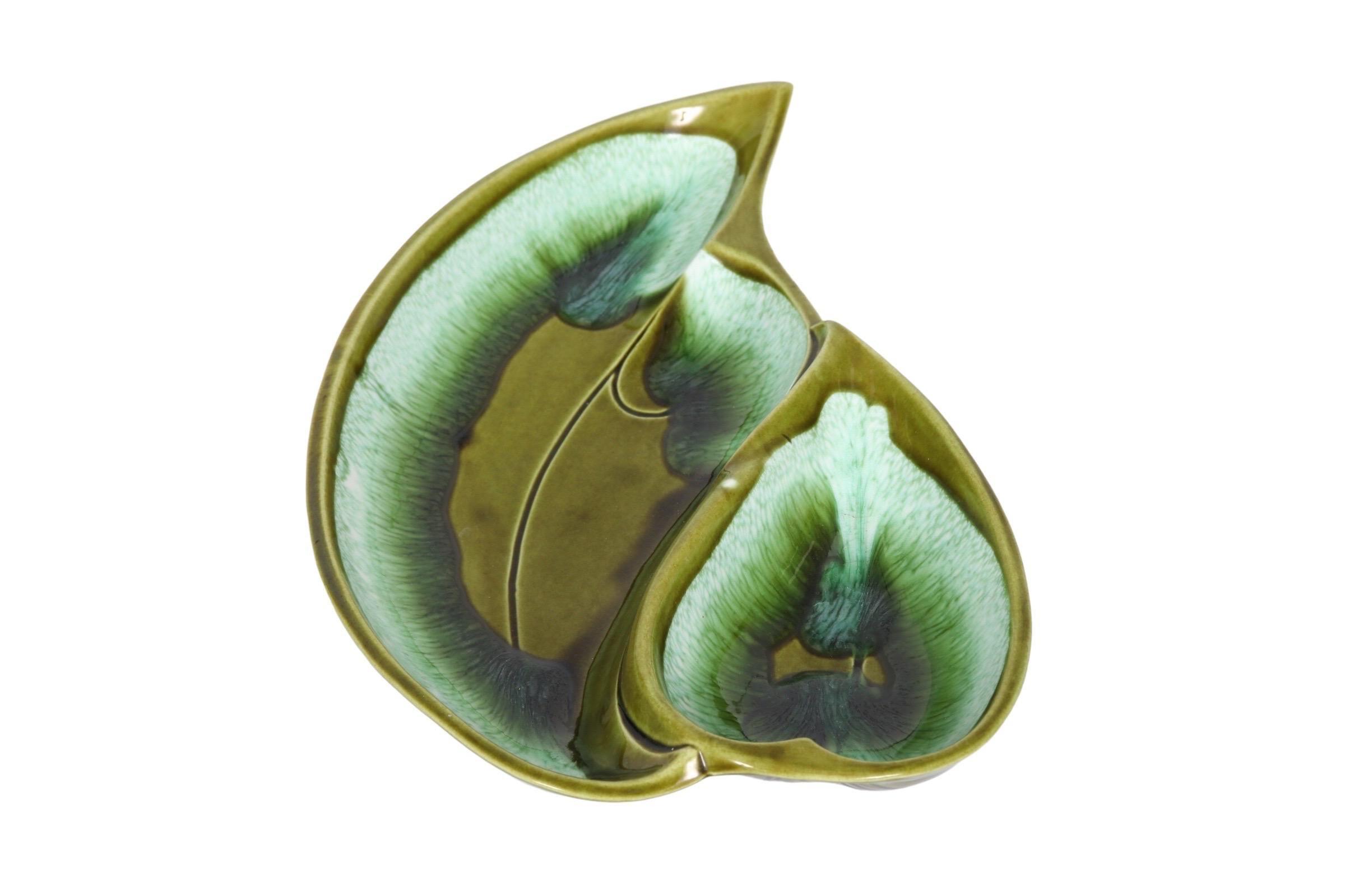 A Mid-Century Modern ceramic serving dish circa 1960, drip glazed in vibrant green hues and shaped like two adjacent leaves. Signed underneath “Santa Anita Ware R-17”.
 