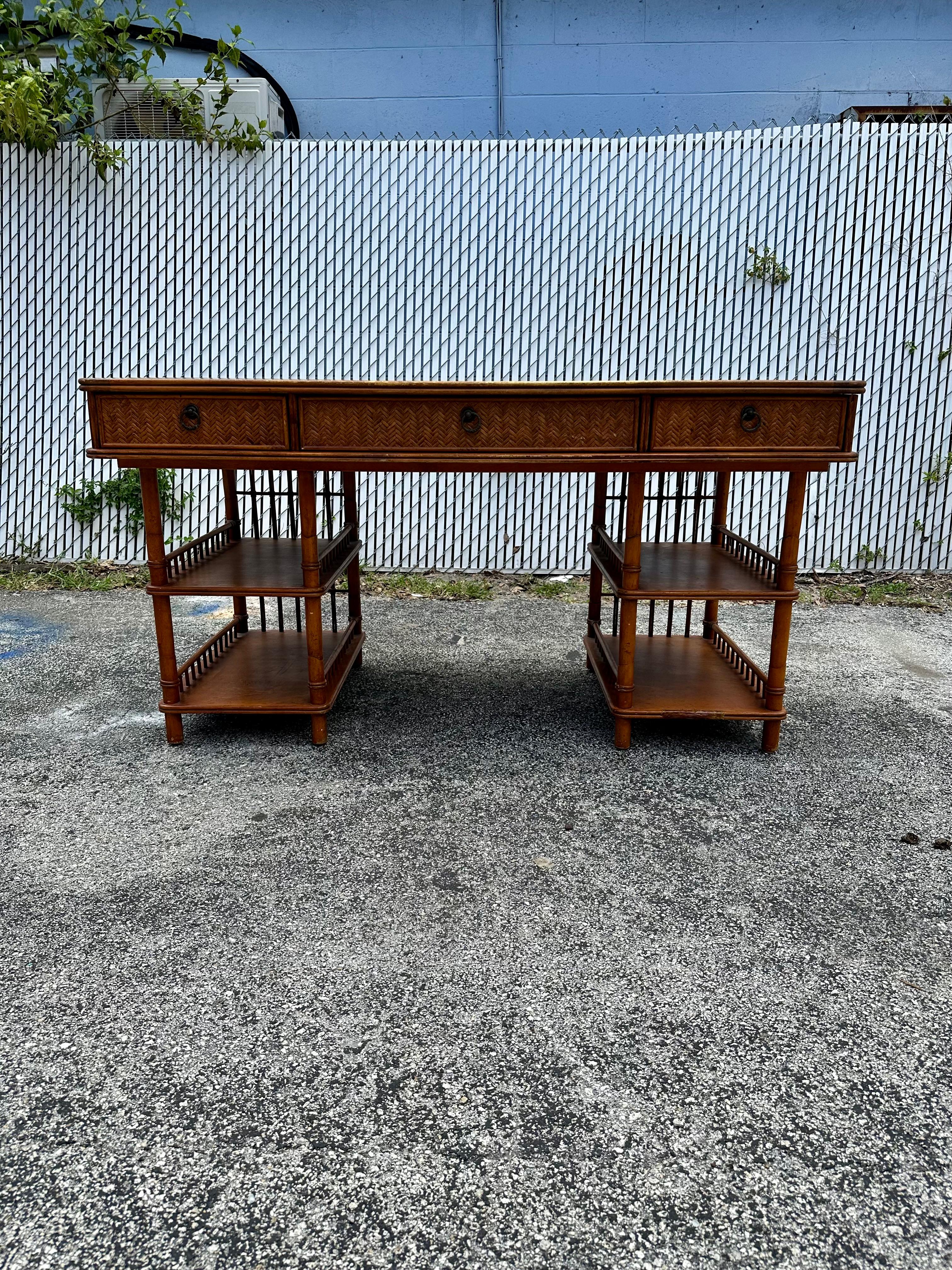 Transport yourself back to the sleek and sophisticated 1960s with this exquisite rattan with leather top desk. The ultra rare desk exudes an air of luxury and refinement. Outstanding design is exhibited throughout. The luxurious desk is statement