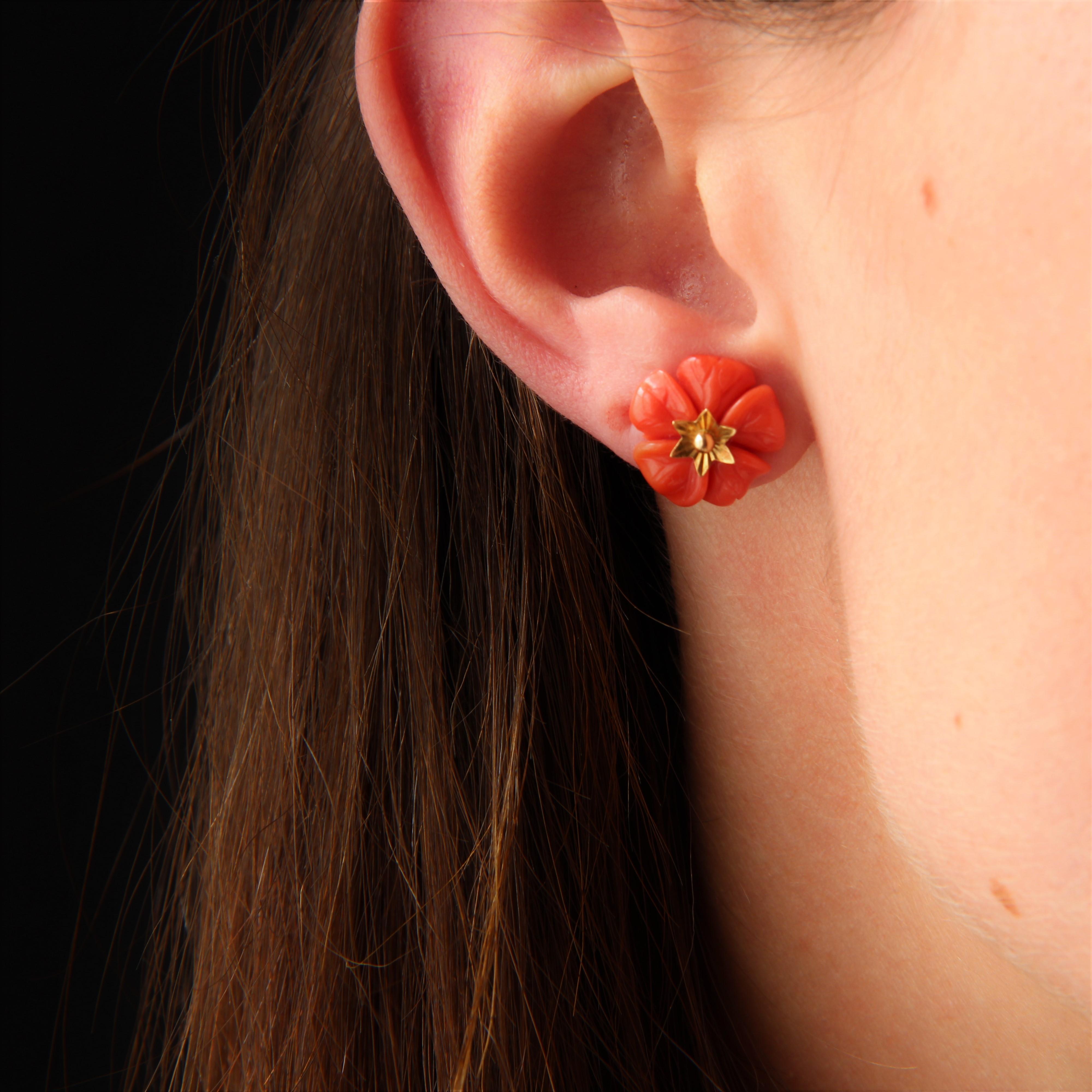 For pierced ears.
Earrings in 18 karat yellow gold.
These coral and gold earrings feature an engraved coral flower, pierced by an ear stud decorated with a small chased gold star. The clasp is a butterfly clasp.
Diameter of coral flower :14 mm