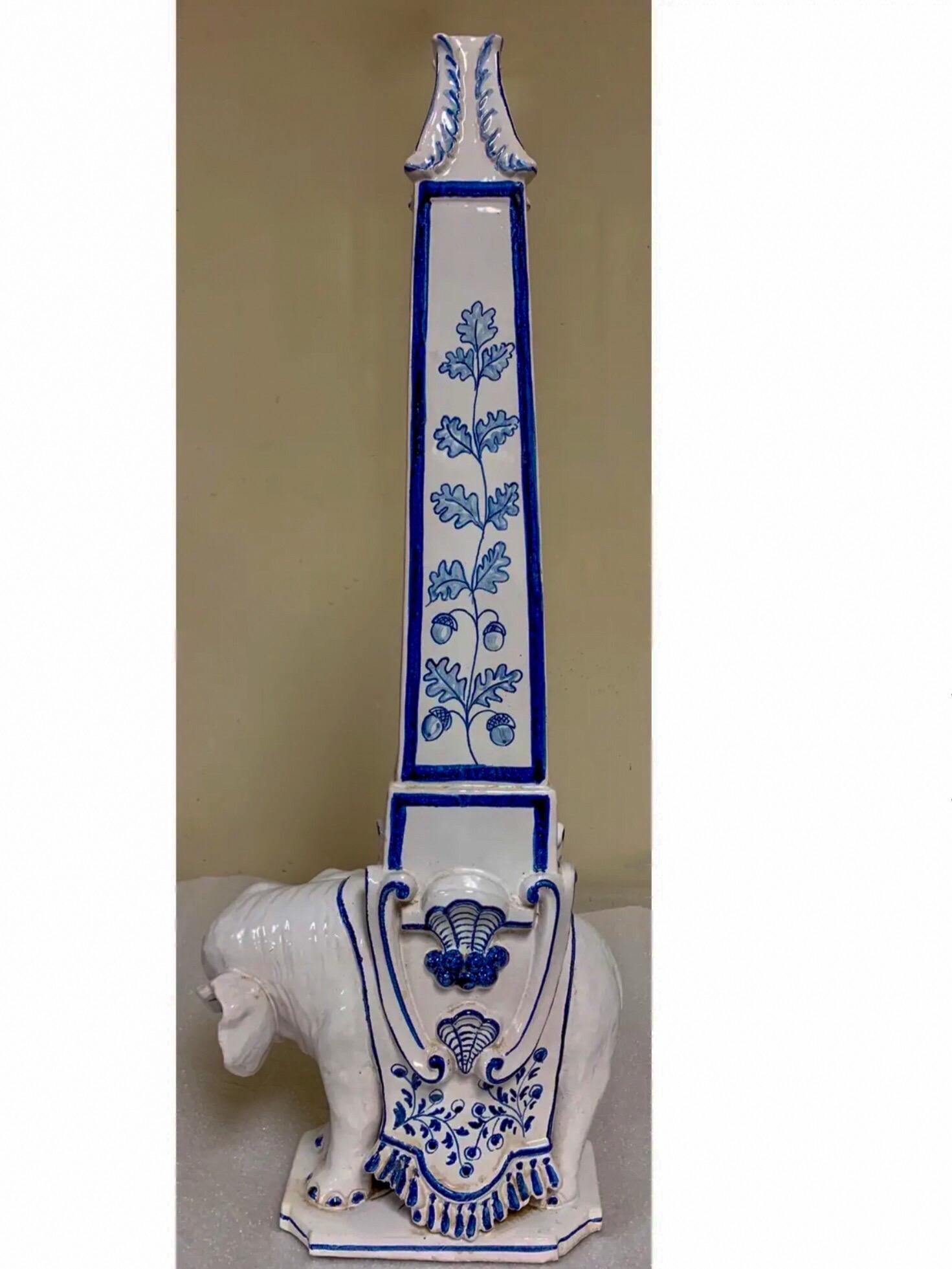 This is a 1960s signed and numbered pair of blue and white terracotta elephant obelisks hand crafted by Meiselman Imports in Italy. They are in very good condition.
