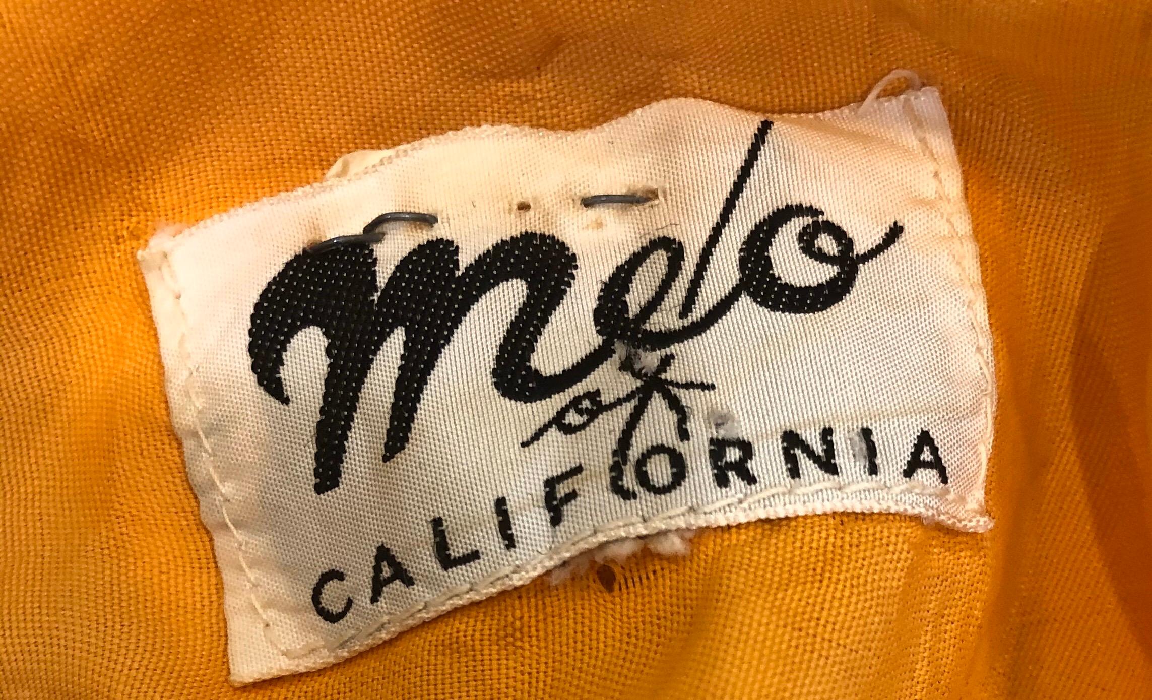Chic robe fourreau en coton imprimé de fleurs orange, vertes et roses de MELO OF CALIFORNIA du début des années 60 ! La toile de fond est d'un orange fluo vibrant, avec des fleurs imprimées dans des couleurs vives comme le rose, le vert kelly, le