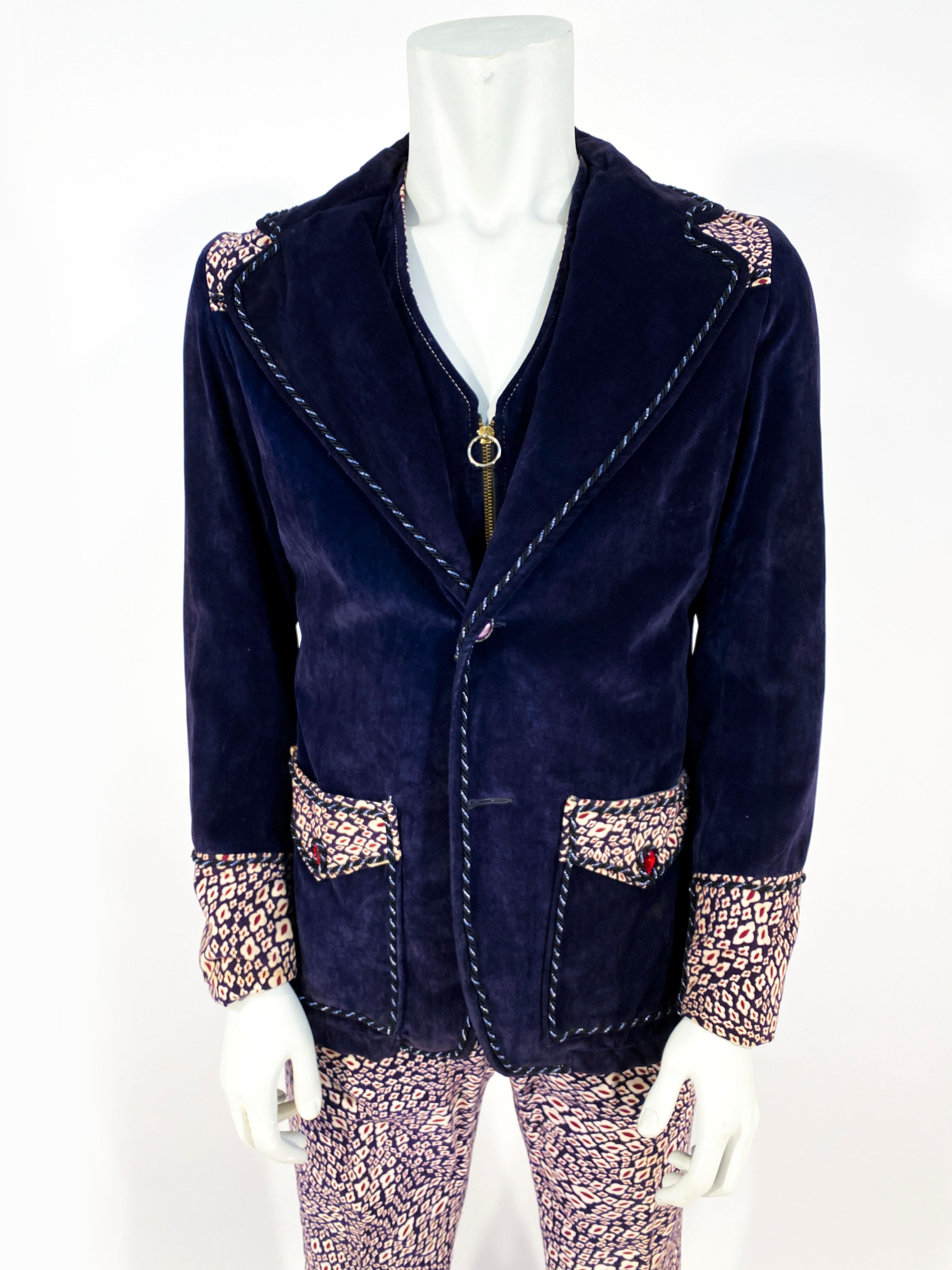 1960s custom-made men's mod cotton velvet three-piece (jacket, vest, and pants) suit. The cotton velvet is an eggplant purple in color with cream and red contrast fabric in the jacket accents, vest, and pants. The vest is reversible with a plain