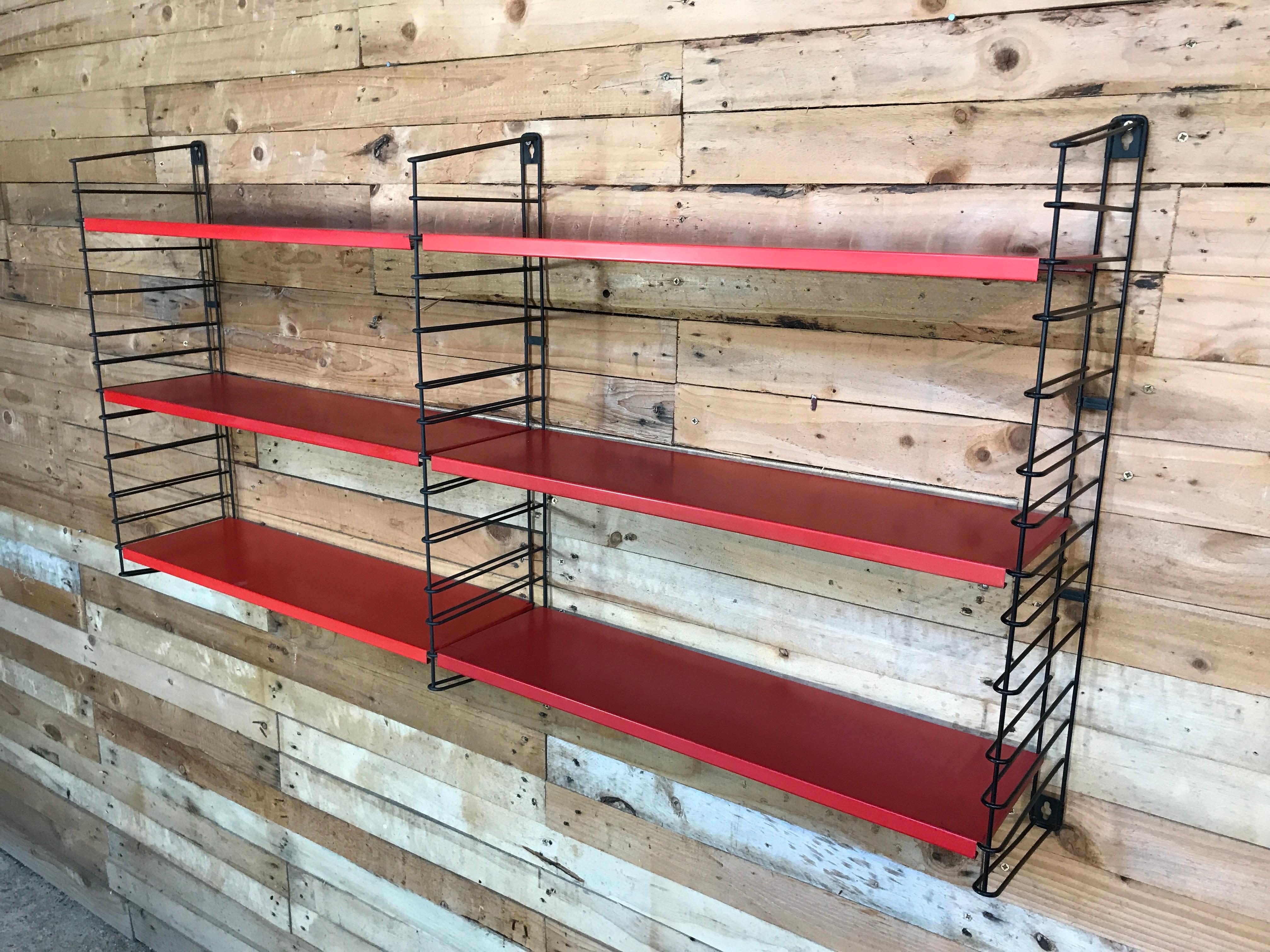 1960s metal black ladders red modular Tomado wall unit designed by A. Dekker.

This shelving unit is made to hold books and is remarkably strong.