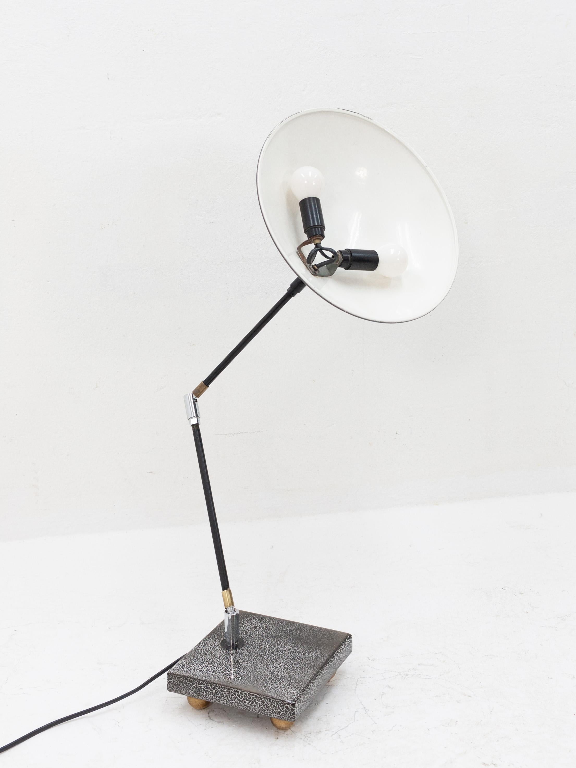 Curious Memphis style metal desk lamp featuring a typical 1980s style shade/armature assembly mounted to an unusual square metal base on brass ball feet. Three ball joints in the long segmented arm allow the user to aim the light in any desire they