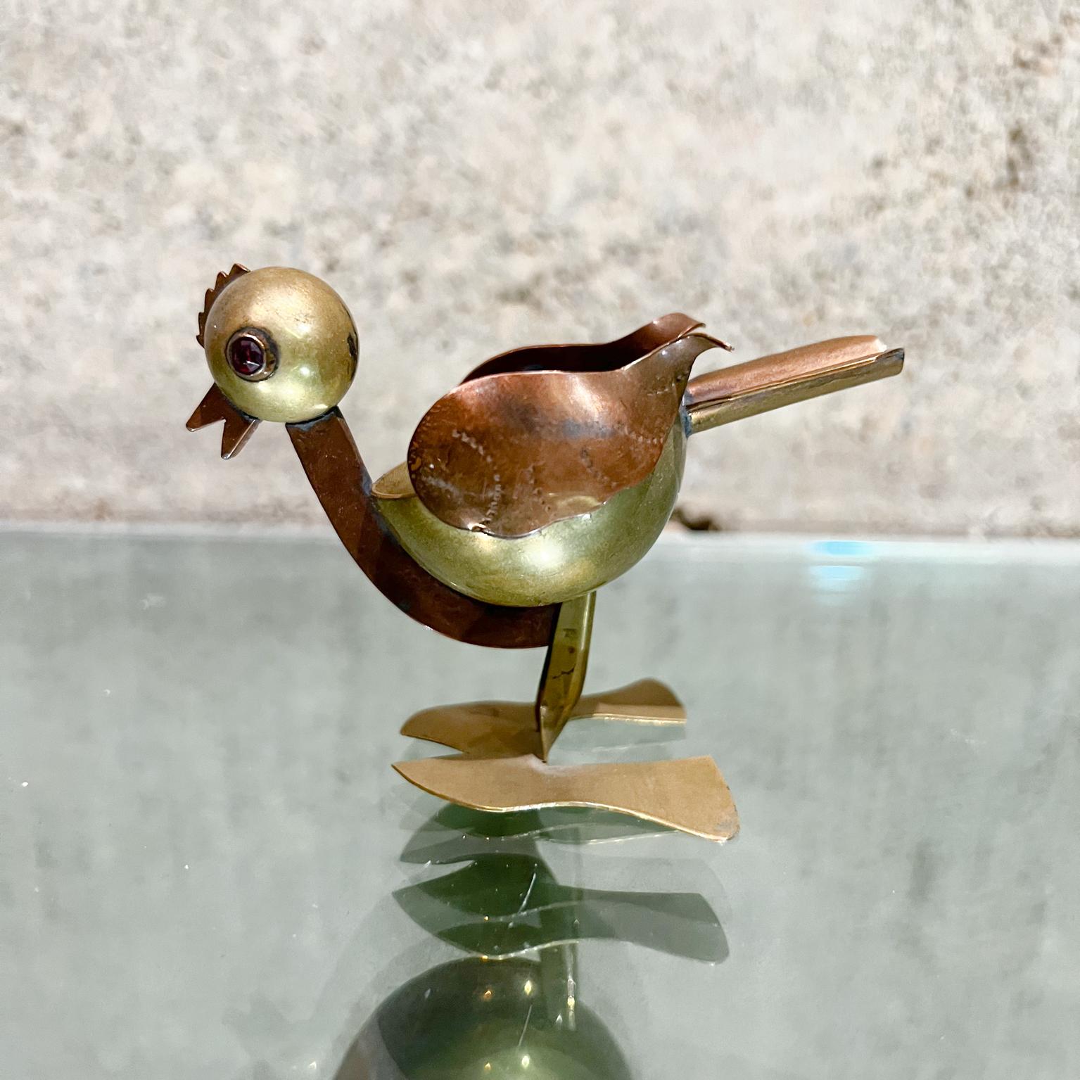 AMBIANIC presents

1960s Mexican bird mixed metal ashtray style los castillo ruby red eyes
Measures: 2.5 tall x 1.5 wide x 3.5 deep
Hand made in Mexico.
Unmarked
Married metals bird serves as an ashtray or catch all, ring holder.
Eyes appear