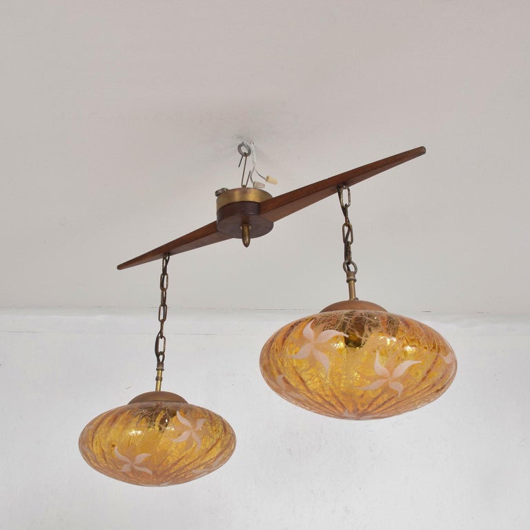 Pendant
1960s Eugenio Escudero Chandelier Pendant Lamp Globe Swag Ceiling Light
Features Mahogany Wood modern sway bar with a two-globe design etched Hand Blown Glass.
Glass presents sculpturally in a rich warm amber tone. Unmarked
Dimensions: