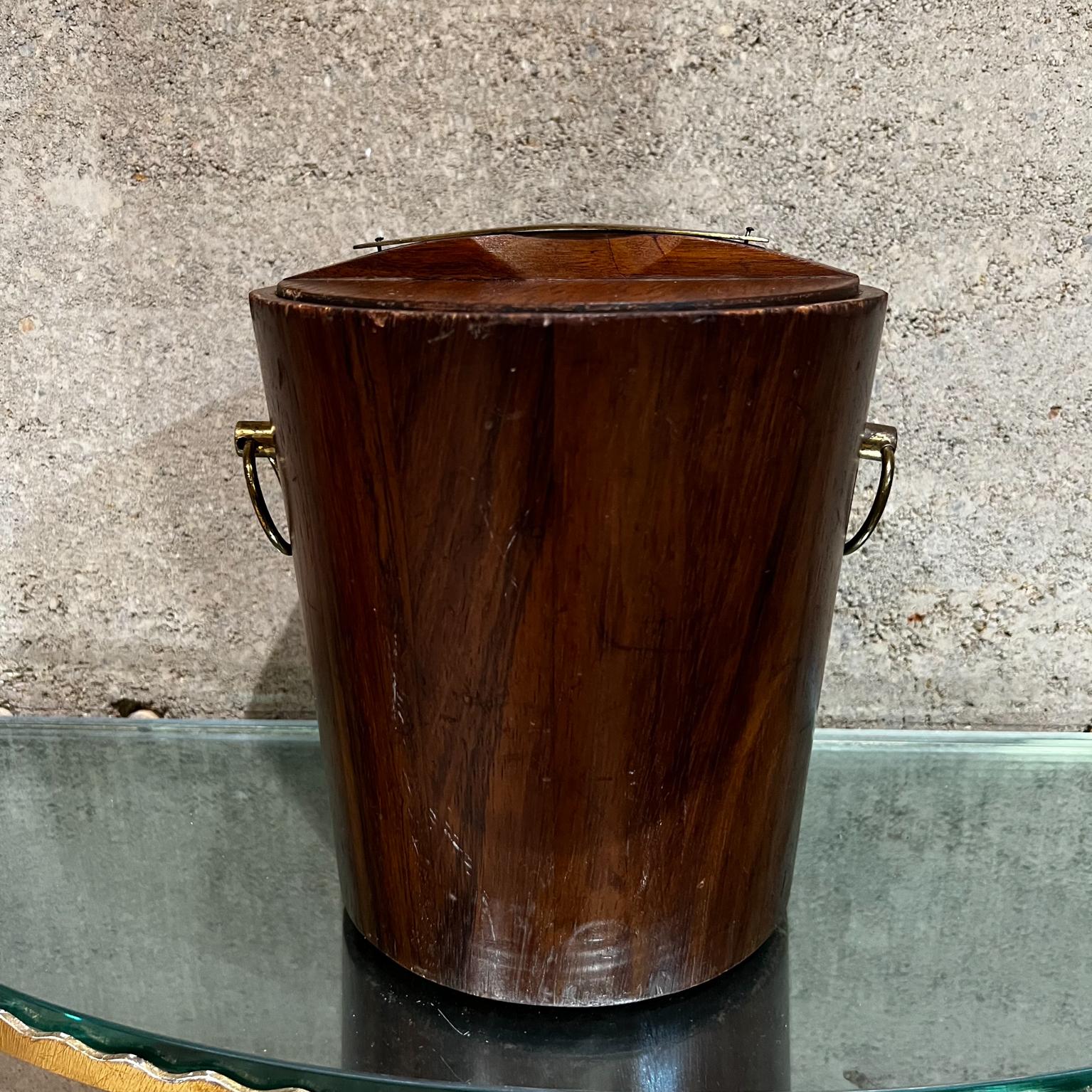Vintage ice bucket made of solid wood with brass hardware.
Made in Mexico circa the 1960s.
Interior has original white liner bucket.
Unmarked. 
9.5 tall x 9.5 diameter
Original vintage unrestored condition. Fair shape.
Refer to all images
