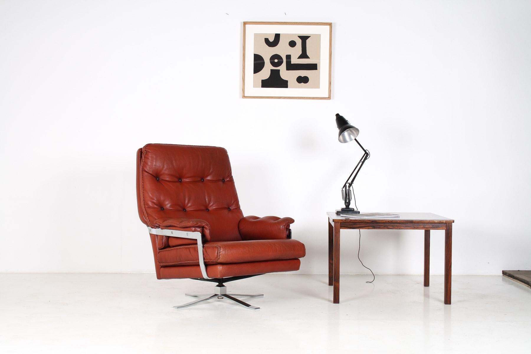A beautifully made 1960s leather swivel chair. A well crafted piece with heavy chrome base and high quality leather with hand stitching. Originally a dark reddish brown, the leather has faded to this wonderful, almost burnt orange colour which gives