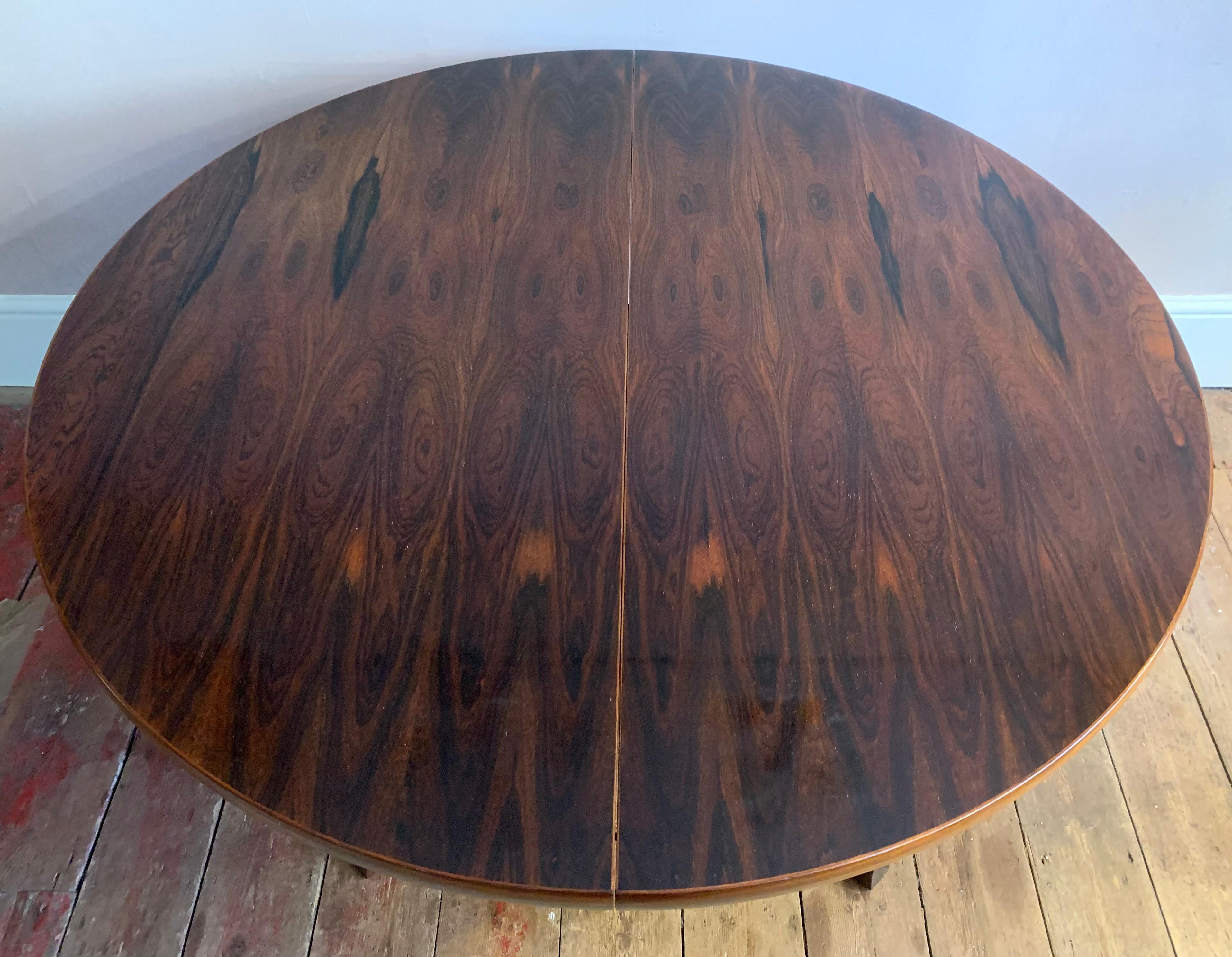 A large oval dining table made from rosewood and manufactured by AM Mobler in Denmark during the 1960s. The table has a beautiful deep grain and is in very good vintage condition. The table is extendable and can be left circular on its cross