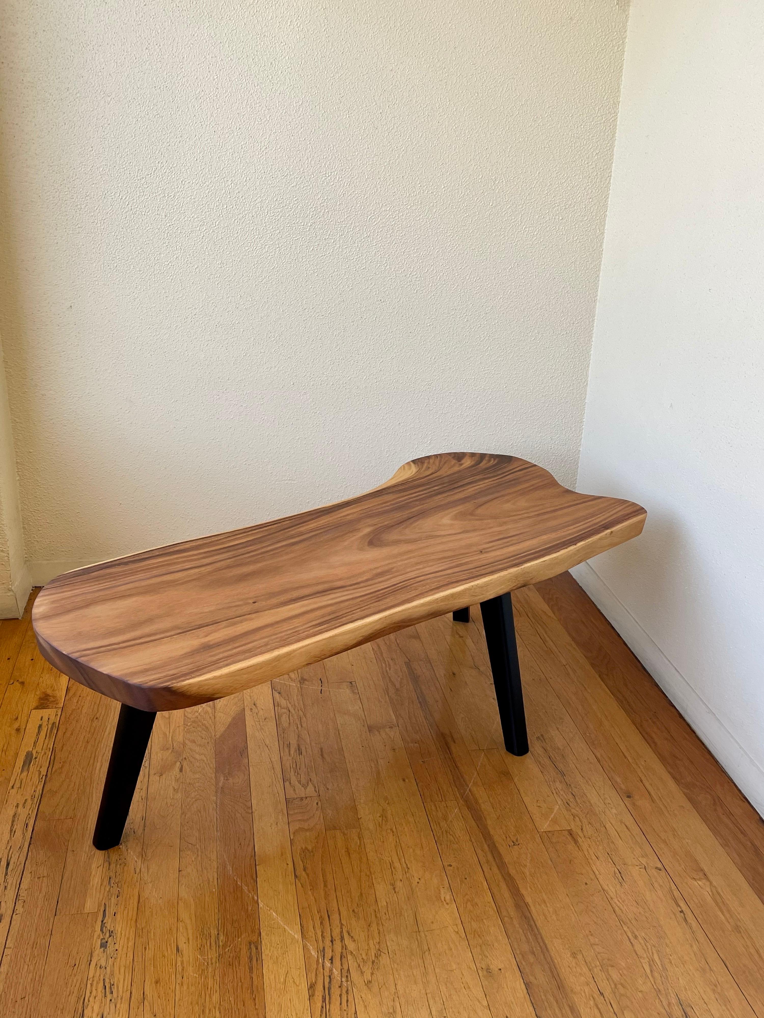 Beautiful three-legged solid thick monkey pod wood, free-form coffee table, sitting on three solid black lacquer legs, nice grain and unique shape freshly refinished.