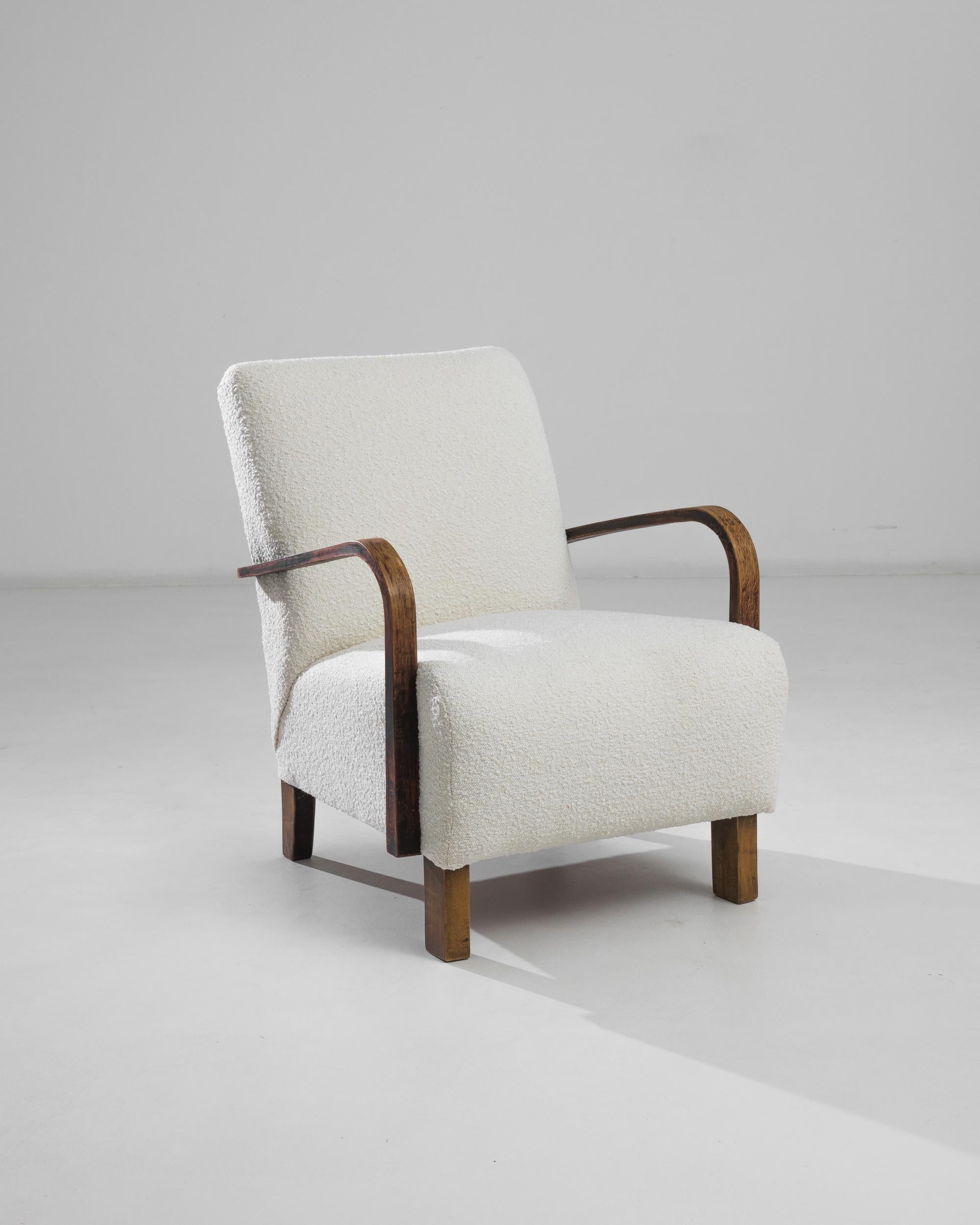 Produced in the former Czechoslovakia, this 1960s design is reupholstered in an airy white bouclé, chosen to compliment the elegant polish of the hardwood frame. Comfortable angles and clean lines are designed to comfort and delight, presented