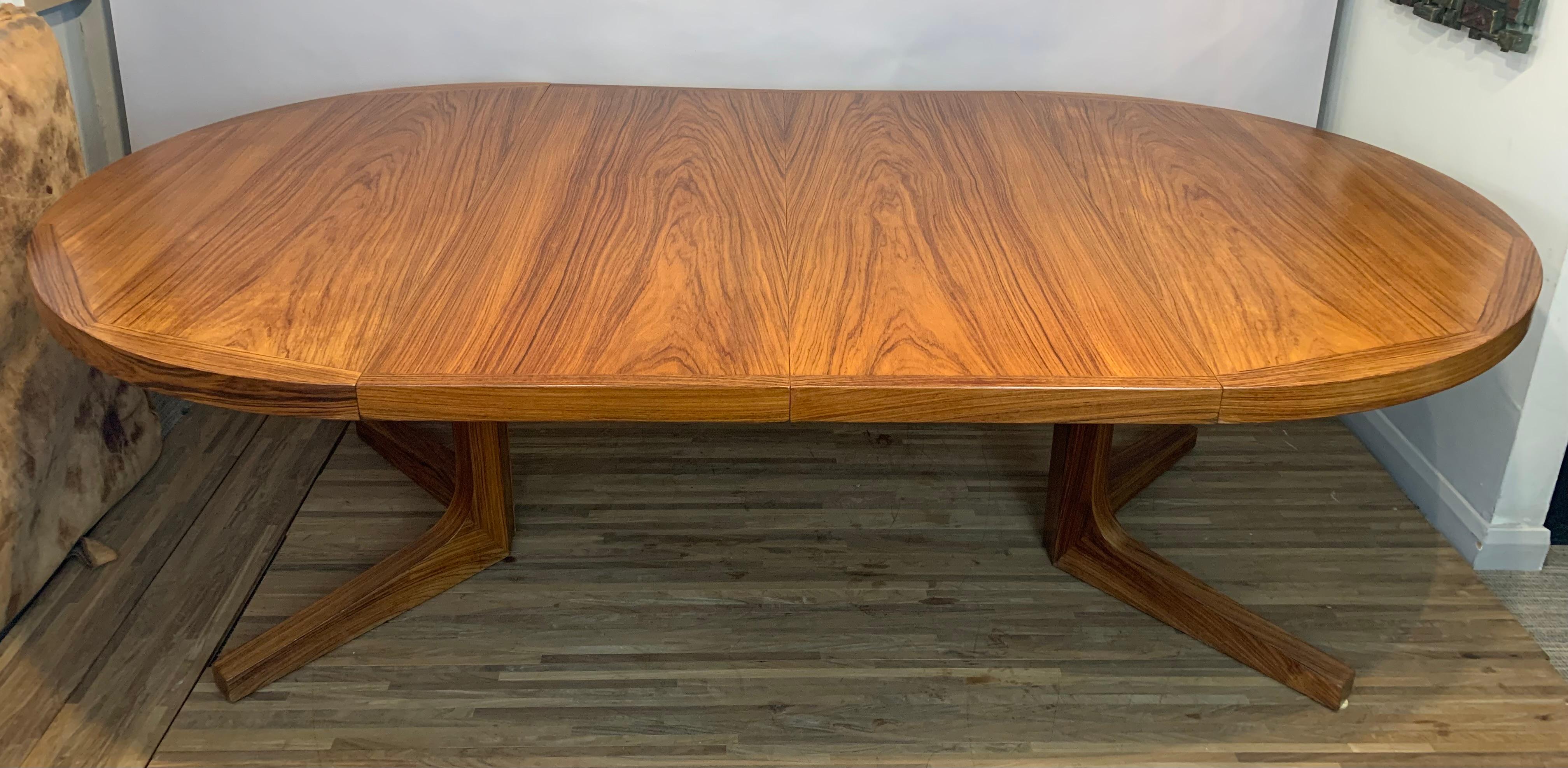 1960s Rosewood dining table manufactured by Dyrlund in Denmark. The pedestal table has two 50cm wide leaves which will extend the table to an overall length of 230cm which will allow it to seat 8 to 10 people comfortably. The table has been
