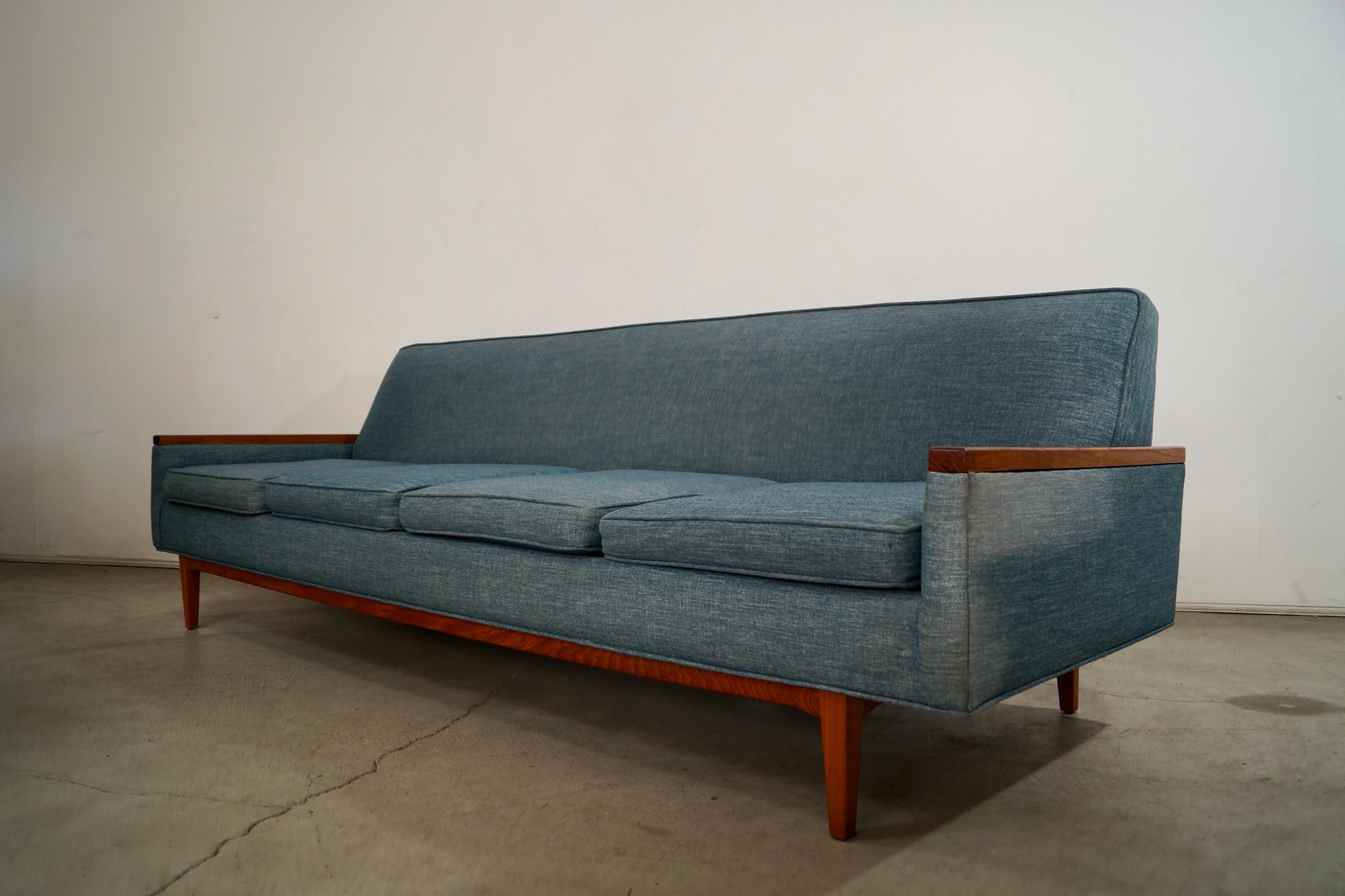 Vintage original Mid century Modern couch for sale. From the 1960's, and has been previously reupholstered in a teal tweed. It has solid teak armrests, and a solid teak base. It has a classic Danish Modern design, and is structurally sound and