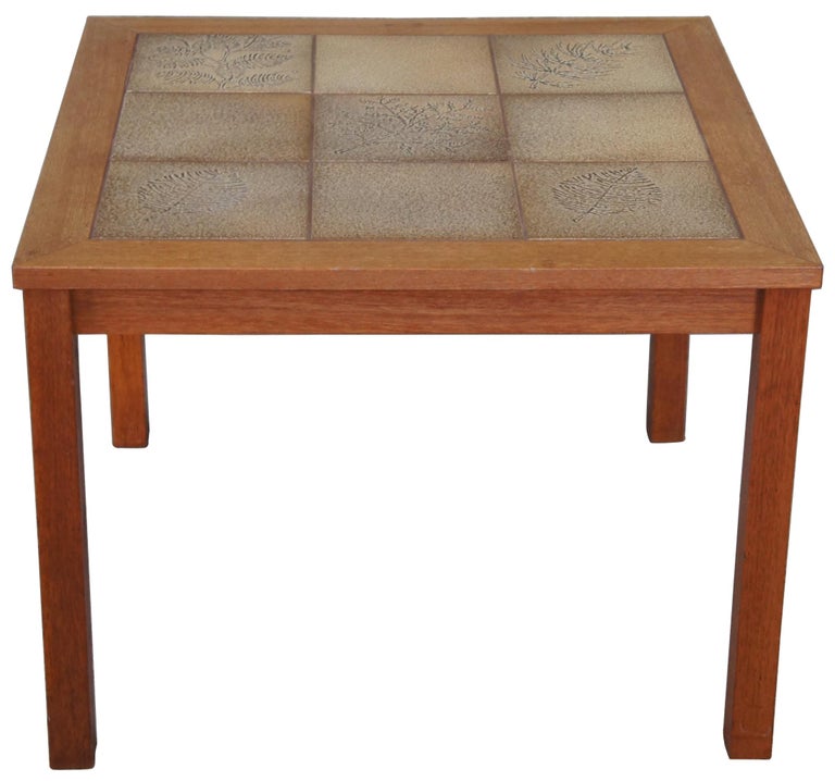 Danish modern square teak side accent table. Made of teak wood featuring a floral / leaf motif tiled top. Measure: 29