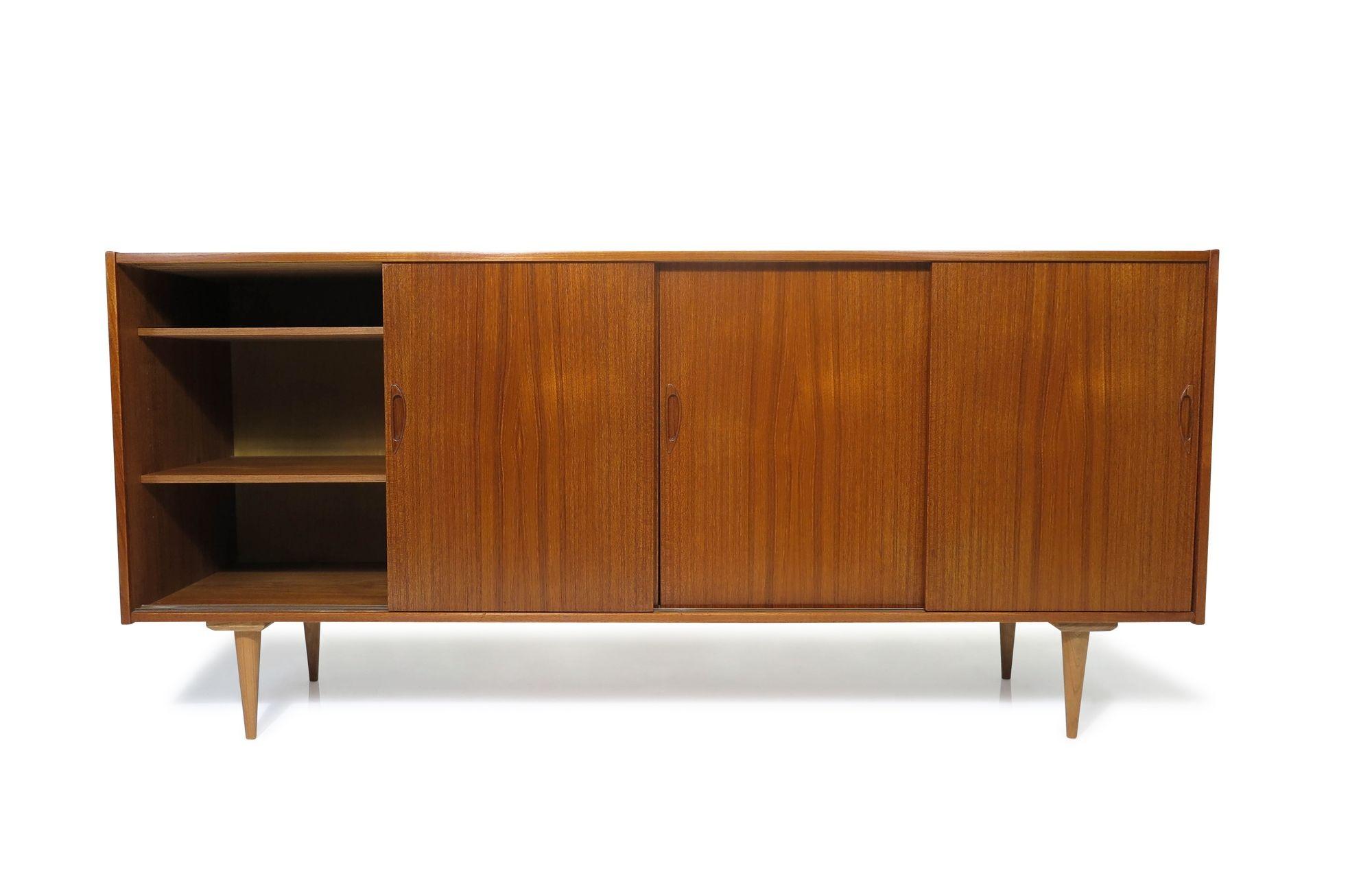 Mid-century Danish teak credenza handcrafted with four sliding cabinet doors opening to reveal an interior of teak with adjustable shelves and three silverware drawers. The cabinet has been fully restored with a hand-rubbed natural oil finish. It is