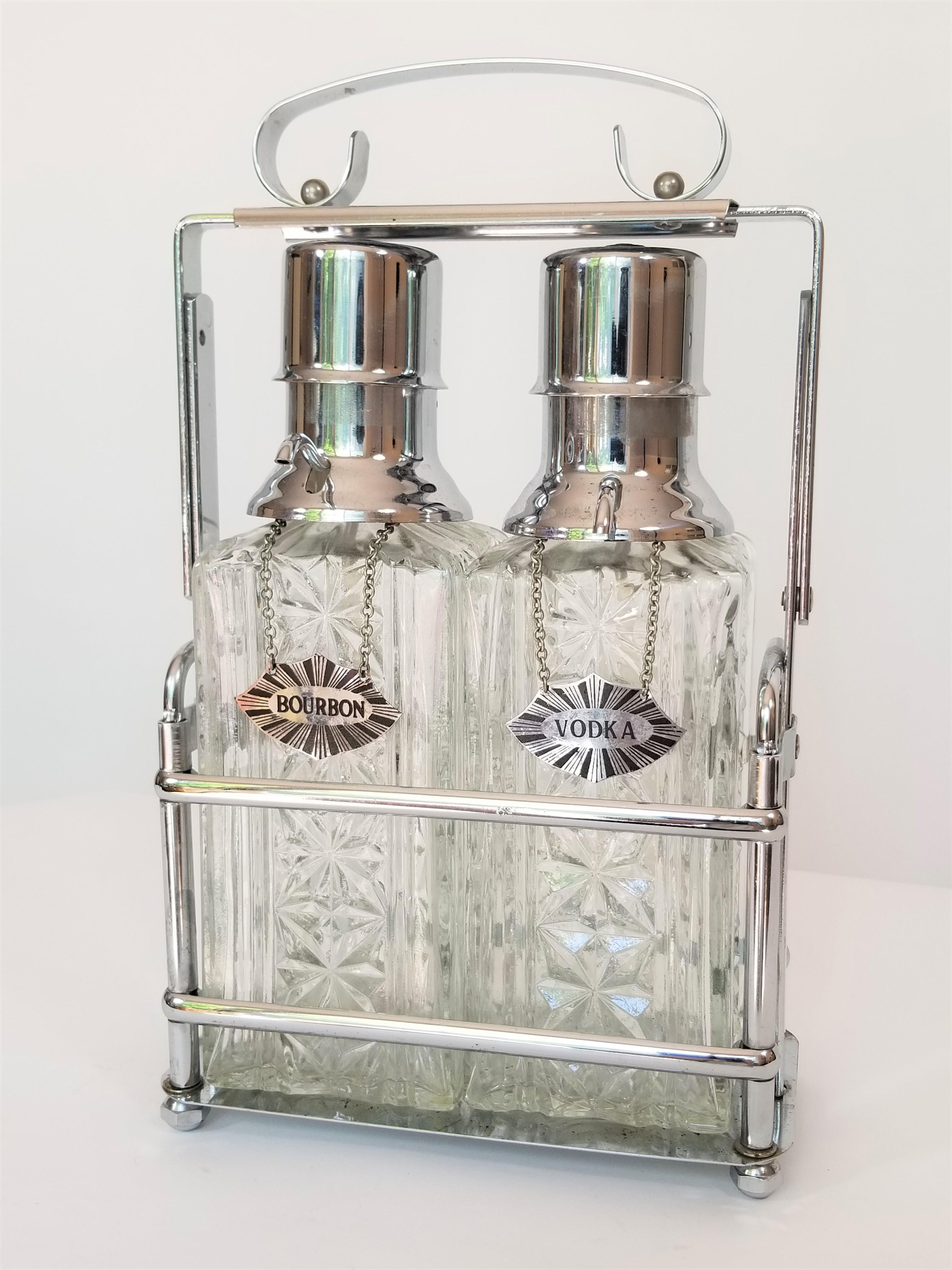 Midcentury 1960s pair of decanters. Chrome caddy holder with handle. Both decanters have a screw on pump top. Metal tags for vodka and bourbon. Sturdy thick decorative glass. Decanters are both in excellent condition. Chrome caddy exhibits some wear