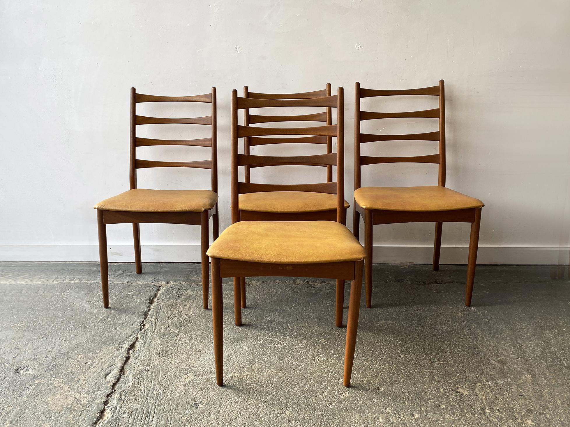 A mid century teak extending dining table with 4 matching high backed dining chairs with the original mustard coloured leatherette upholstery. Produced by Grieves & Thomas a recognised English manufacturer.

Size table
Extended width