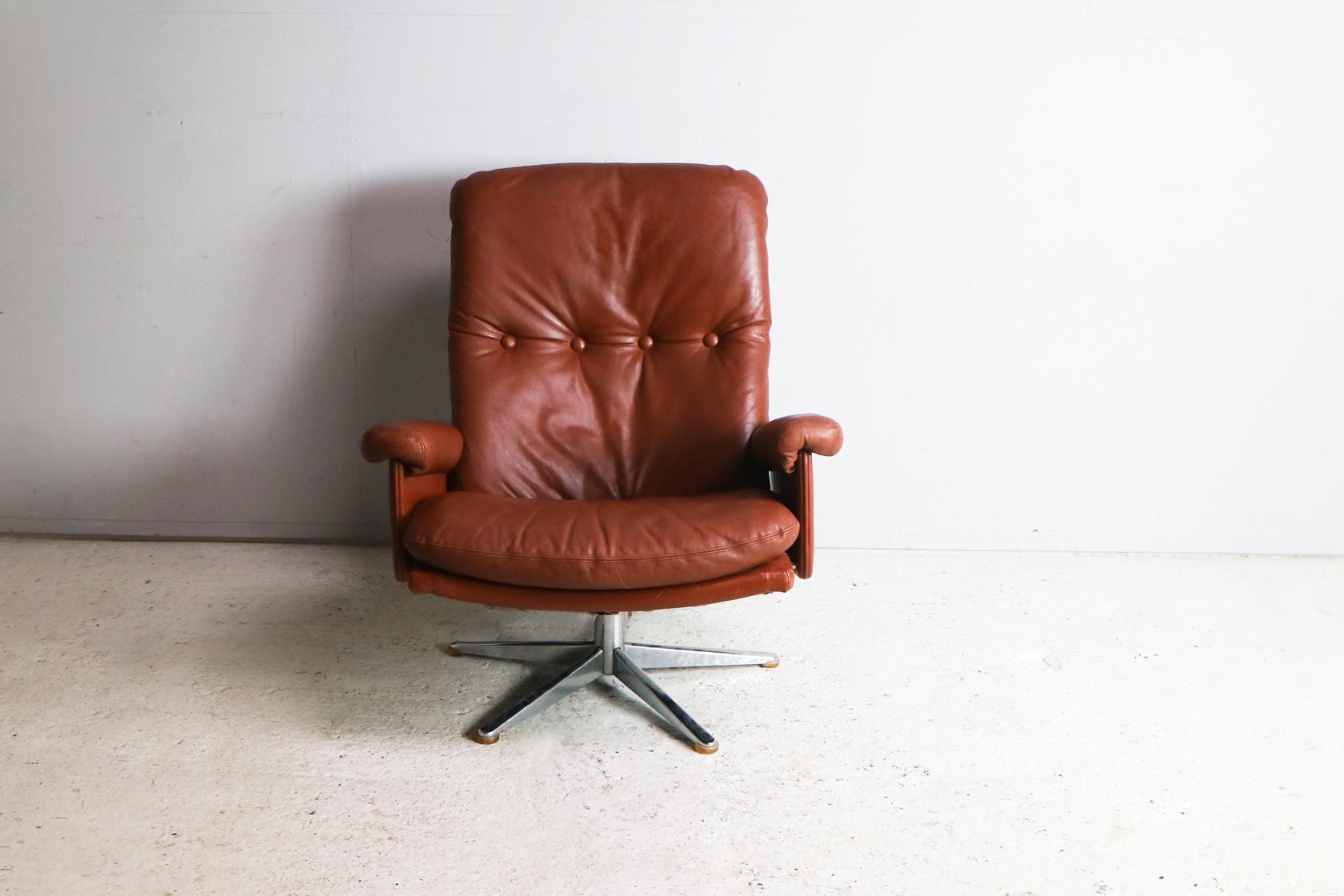 A very elegant Danish brown leather semi reclining swivel armchair or lounge chair designed by Werner Langenfeld and manufactured by ESA Møbelværk in Denmark during the 1960s.

Nice wrap over arm detail, and subtle details to side sections (see