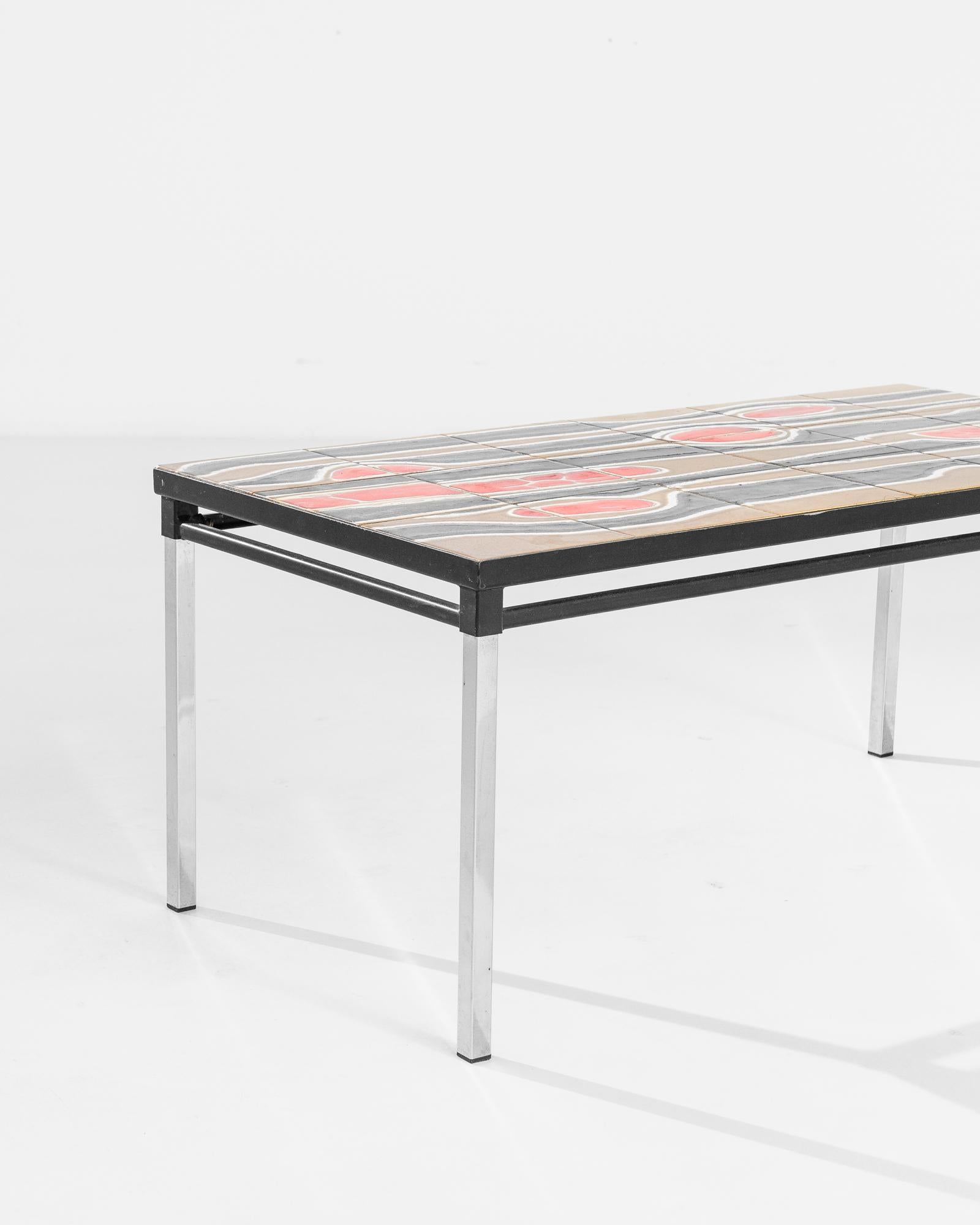 A metal table with porcelain top from France, produced circa 1960. A sleek, metal frame of silver legs and black stretchers support a tiled top in this mid-century table. A porcelain grid of 18 tiles forms an out of this world abstract pattern in