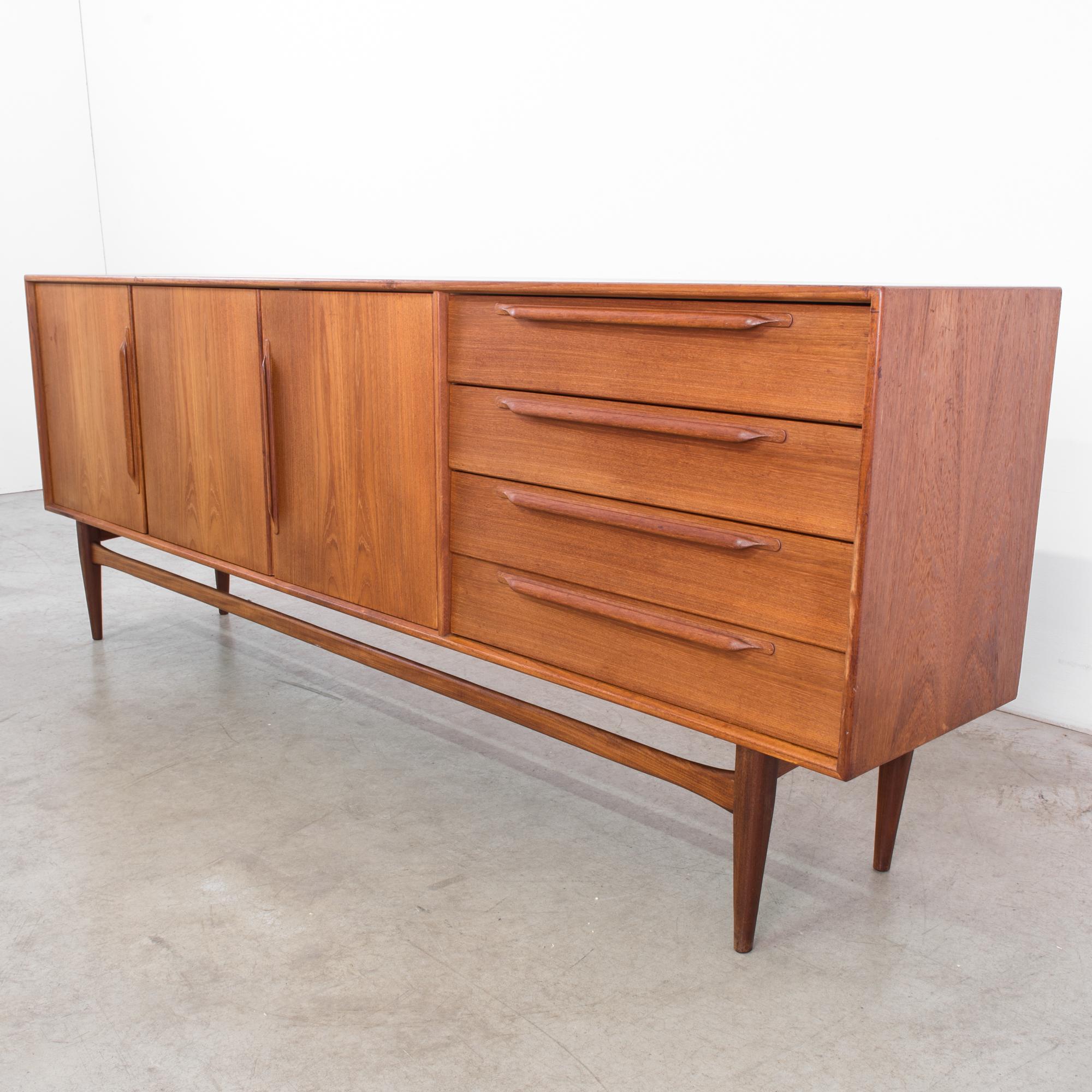 The quintessential vintage sideboard from Germany, circa 1960. A chic chest with three cabinets and four drawers. Measuring over seven feet long this sideboard has style for days. The cool, clean lines of this timeless profile makes you want to grab