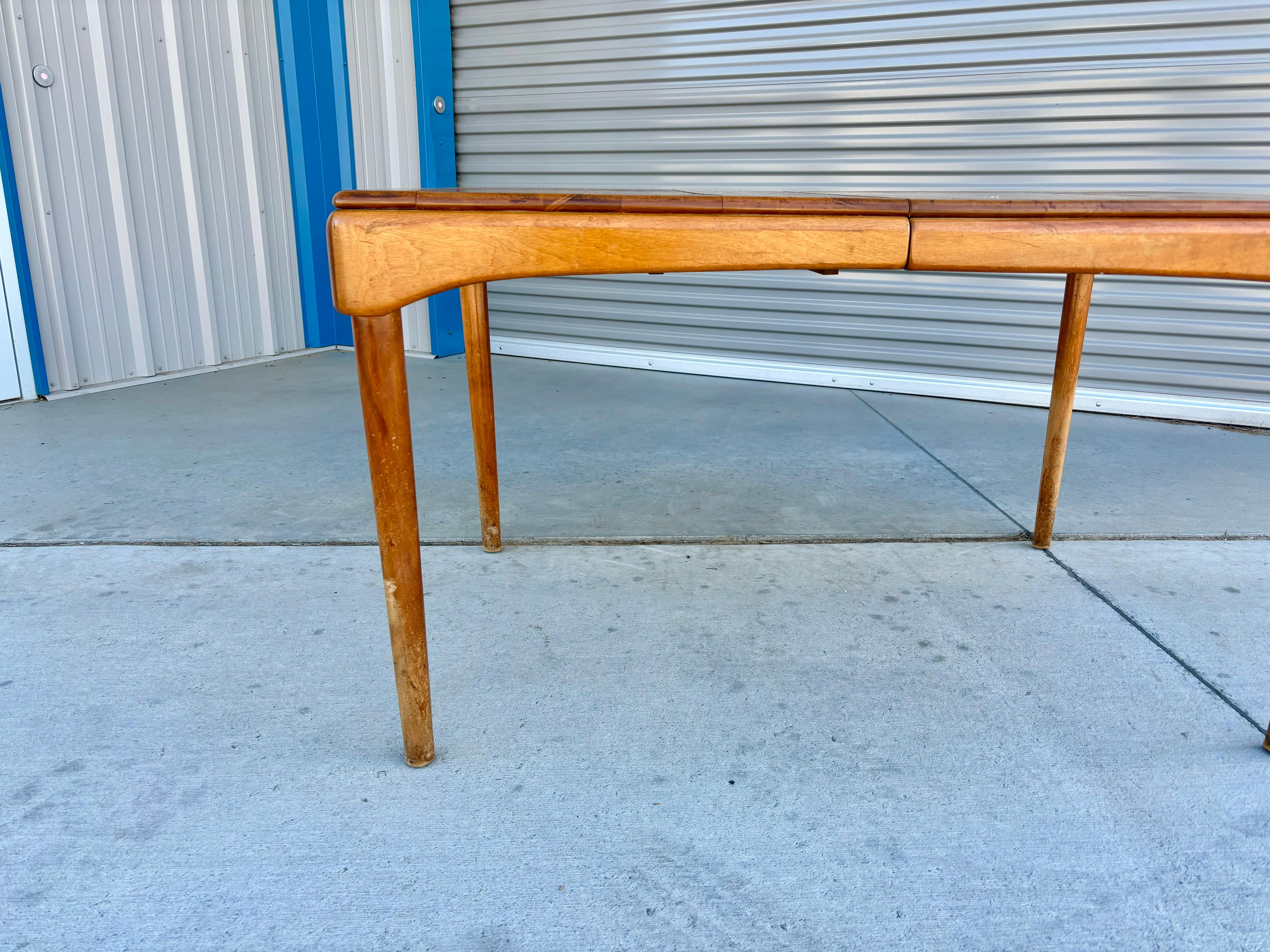 This mid-century maple dining table was designed and manufactured by Heywood Wakefield in the United States circa 1960s. This beautiful dining table features a maple frame. The table also has an extra leaf, providing ample space for last-minute