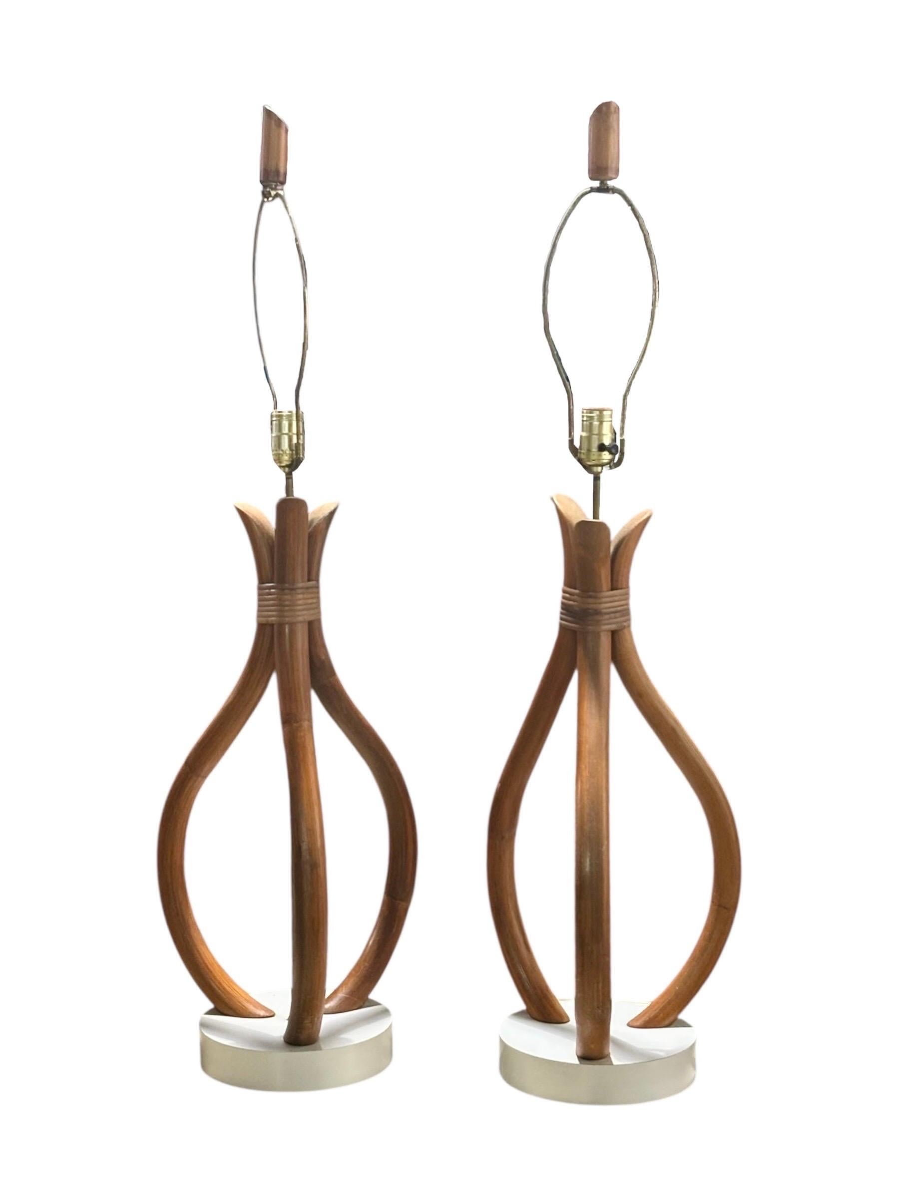 Pareja de lámparas de sobremesa escultóricas de estilo Adrian Pearsall de mediados del siglo XX, de hacia 1960, con pantallas originales de arpillera. Tres piezas de madera curvada de bambú forman un tulipán, sujetas con una envoltura de ratán,